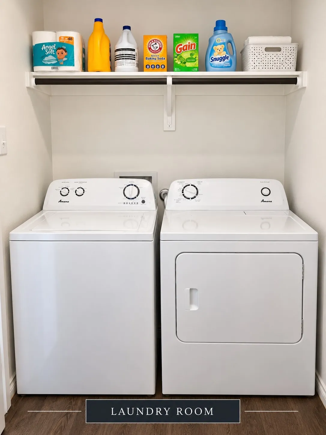 Dedicated laundry area featuring a built-in shelf, hanging rod, and wood-finish flooring