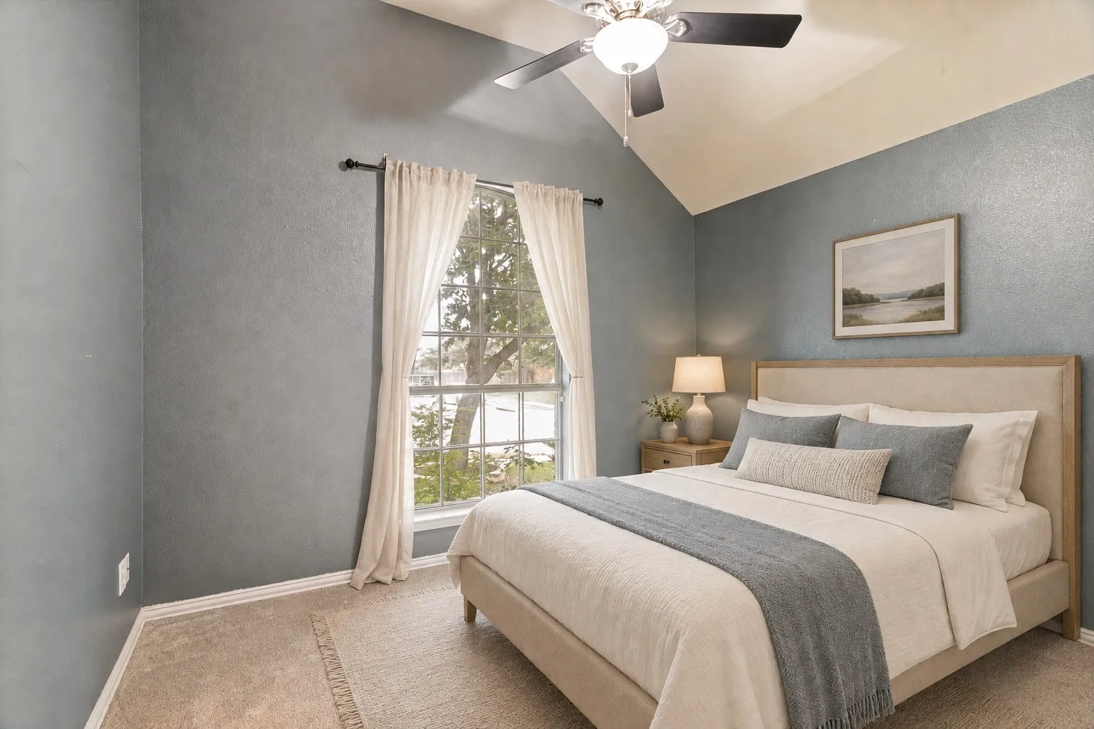Vaulted ceiling featuring a ceiling fan with light, large window, and carpet flooring