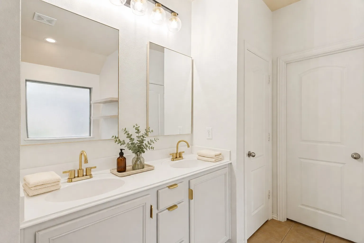 Dual vanity with white countertops and gold-finish fixtures