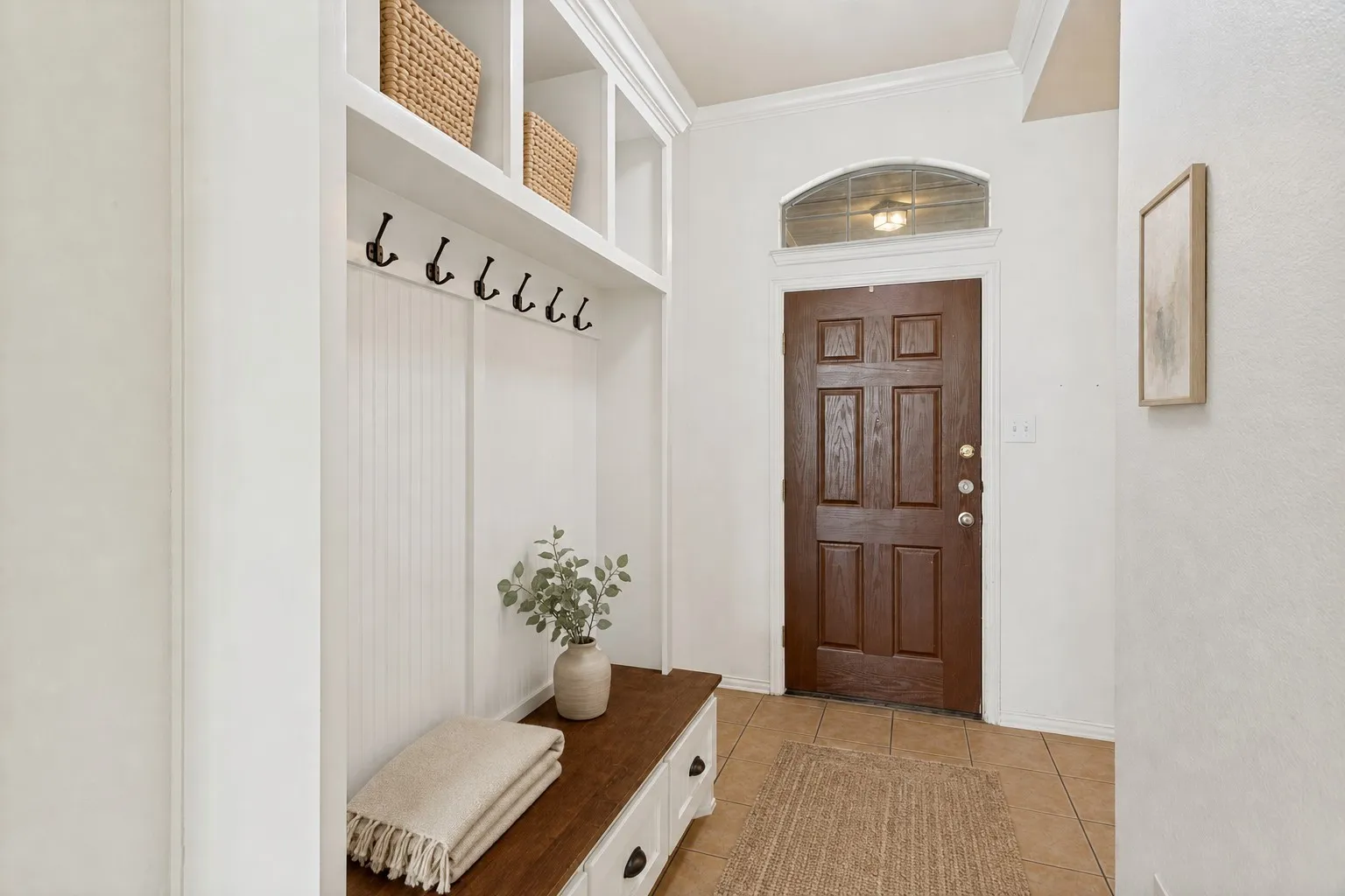 Built-in storage bench with wood-finish top, integrated shelving, and coat hooks