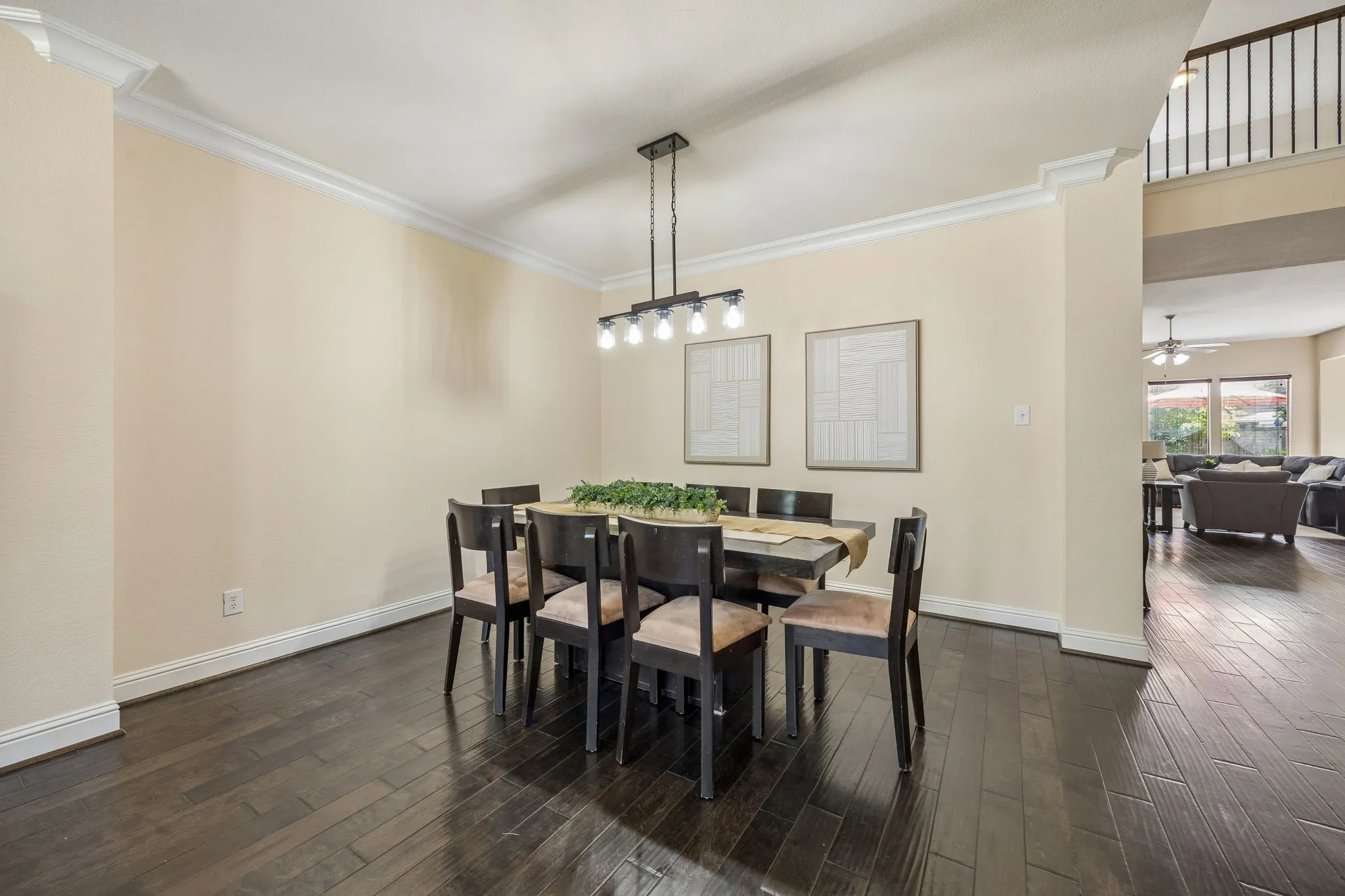 Dark wood-finish flooring with crown molding and recessed lighting