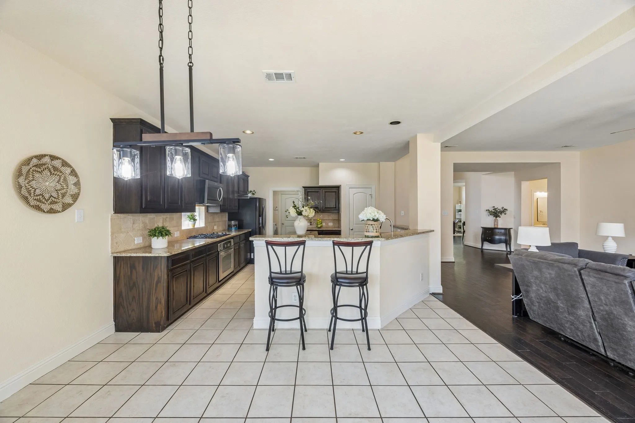 Kitchen with dark wood cabinetry, light-toned countertops, and a tile backsplash