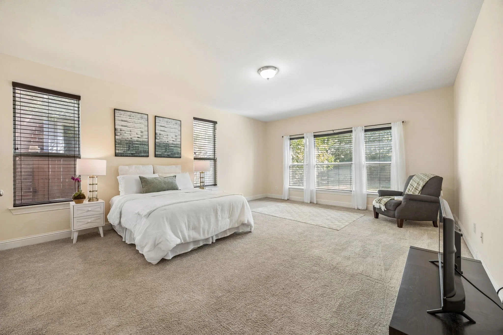 Soft neutral carpeting, multiple windows with blinds, recessed lighting, and a ceiling-mounted light fixture