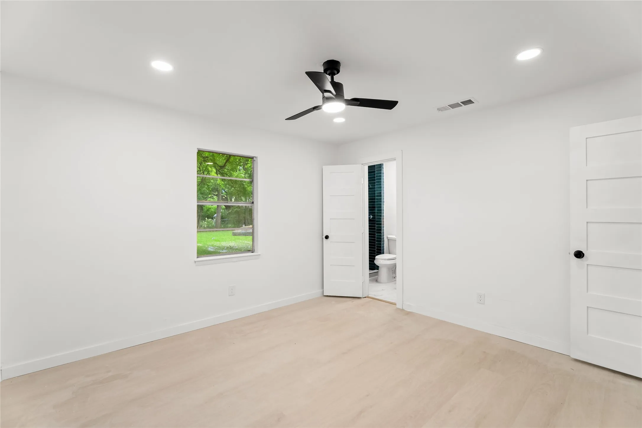 Recessed lighting, a ceiling fan with light, wood-finish flooring, and white paneled doors