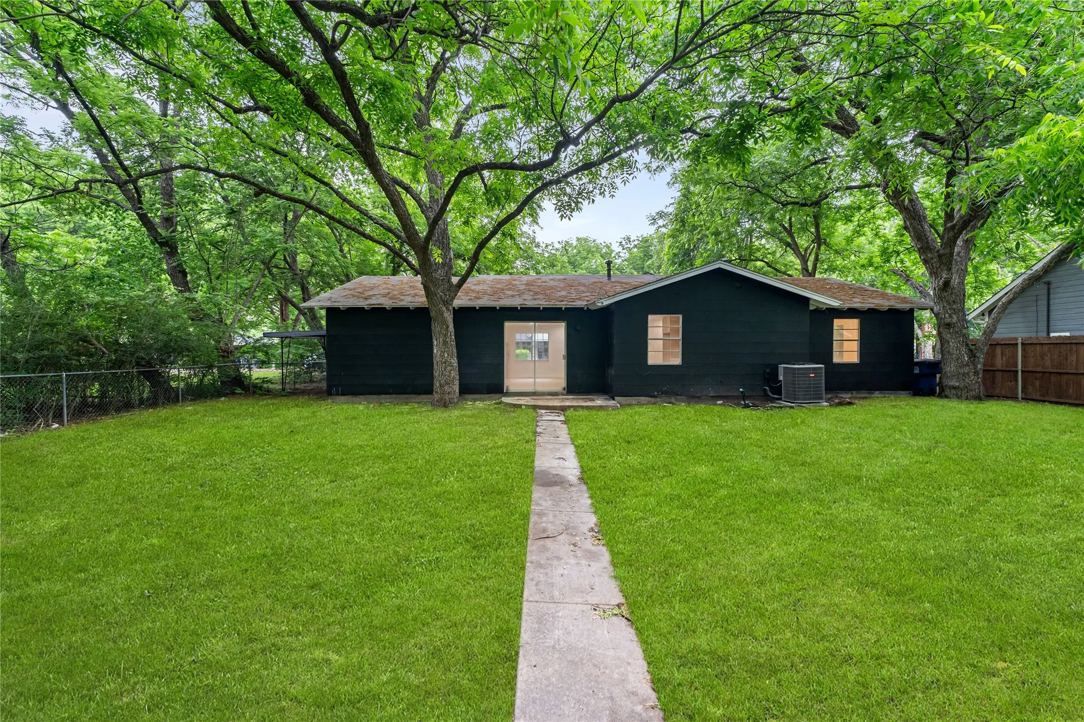Expansive green lawn with a concrete pathway leading to the rear entrance