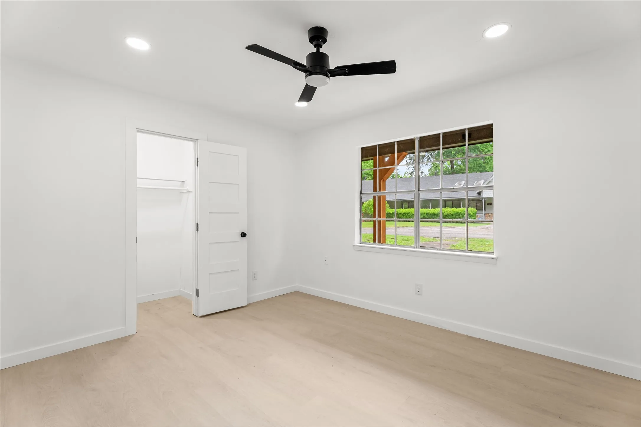 Recessed lighting, wood-finish flooring, a ceiling fan, and a paneled door