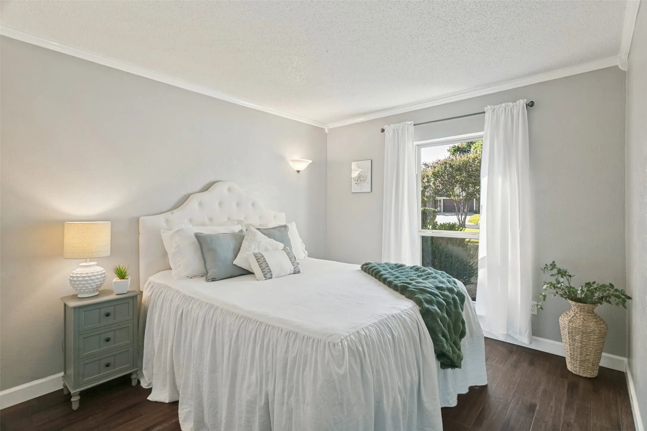 One of the secondary bedrooms with wood floors, crown molding, and plenty of closet space.