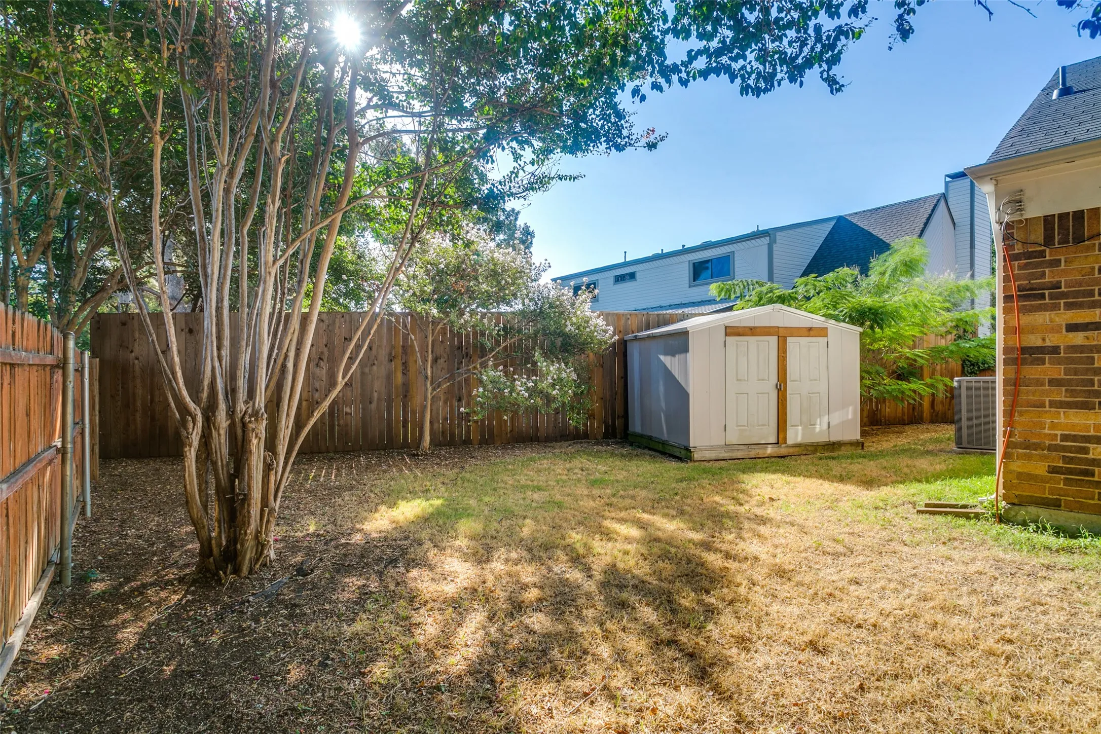 This is the other side of the yard with Crepe Myrtles and a large storage shed that will convey.