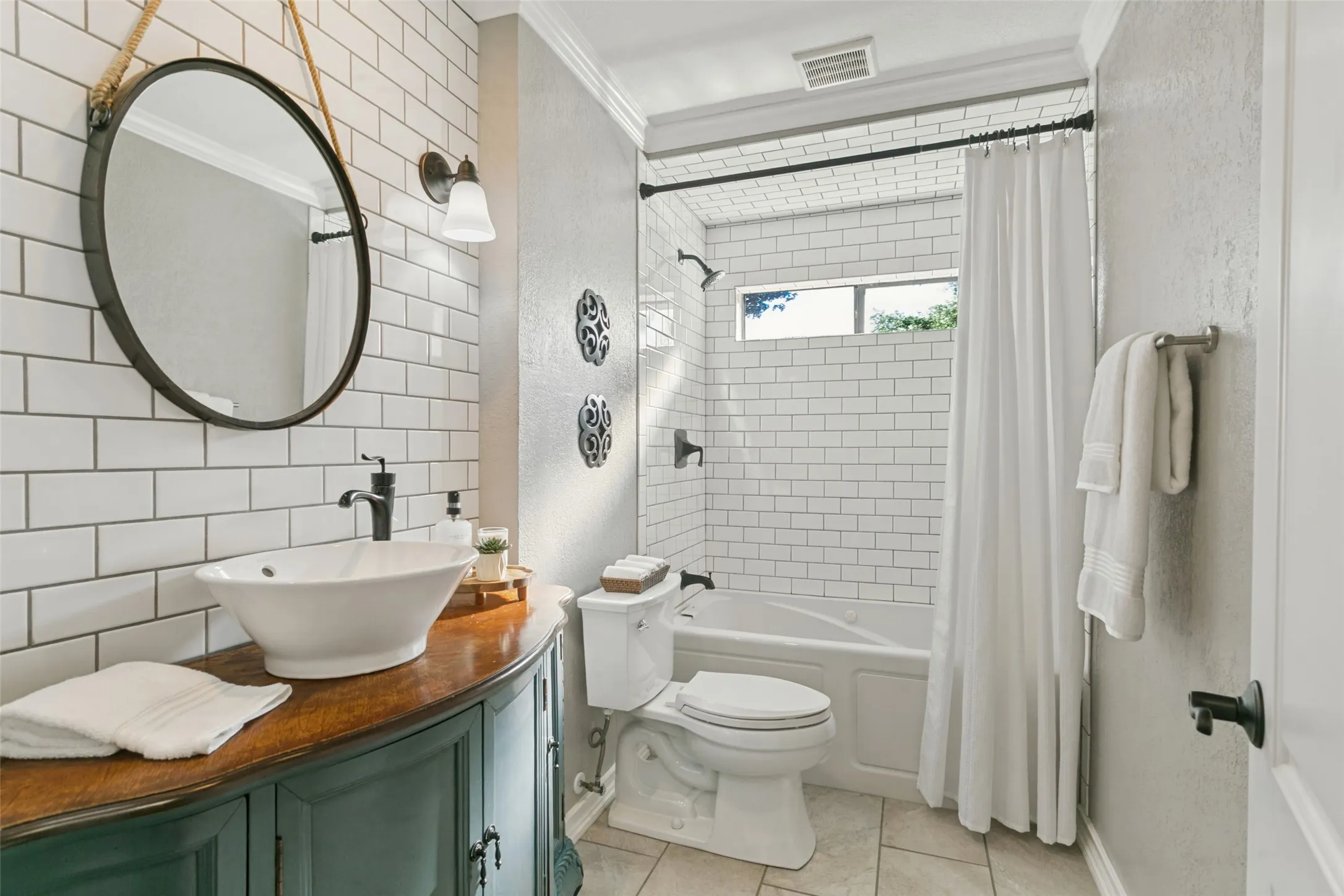 The secondary bathroom is also beautiful with a custom cabinet, crown molding, and an oversized spa-like jetted tub for relaxing after a long day.