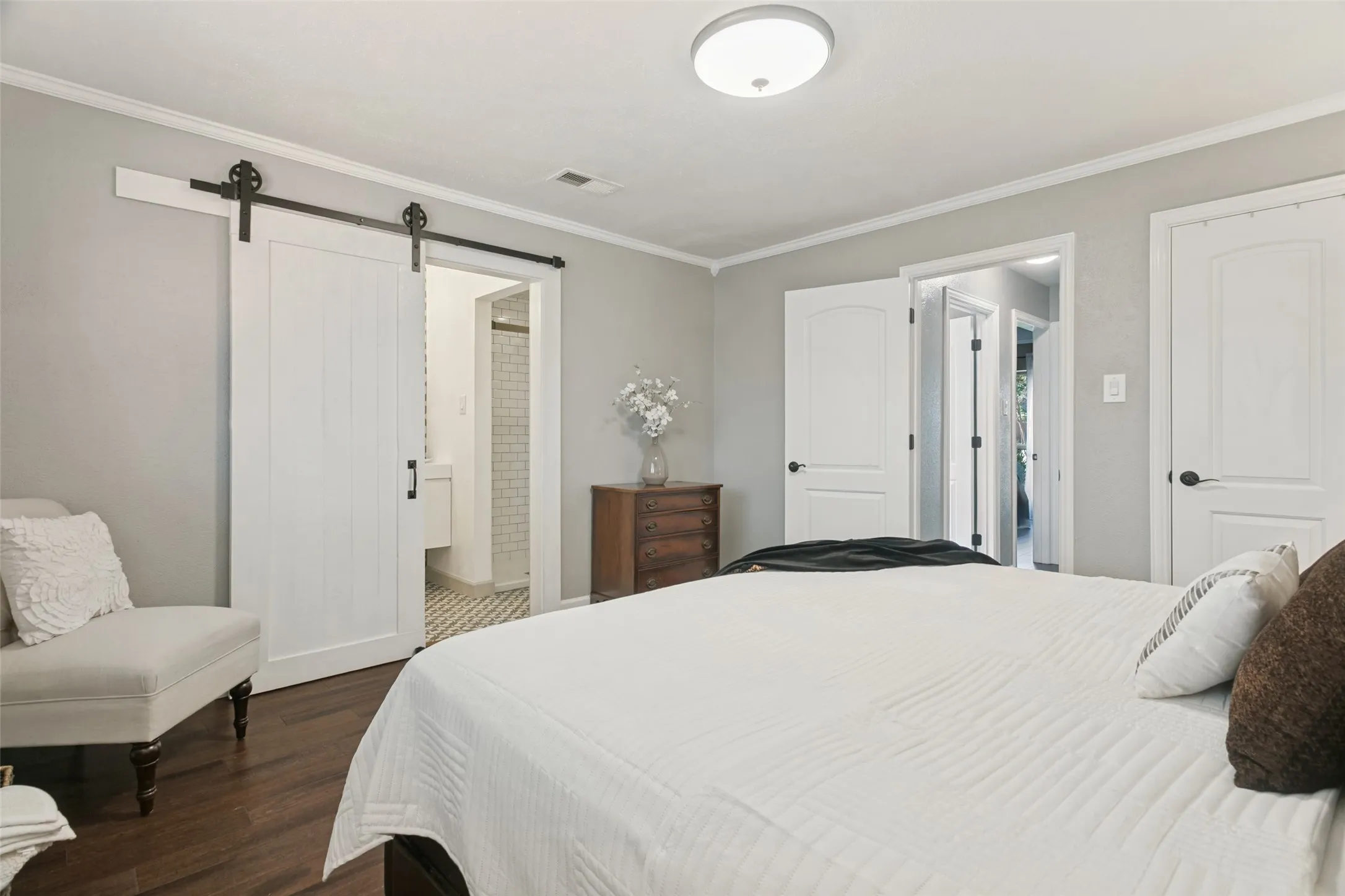 The large master bedroom is complete with wood floors, crown molding, his and her walk-in closets and a barn door leading to your fabulous master bathroom.