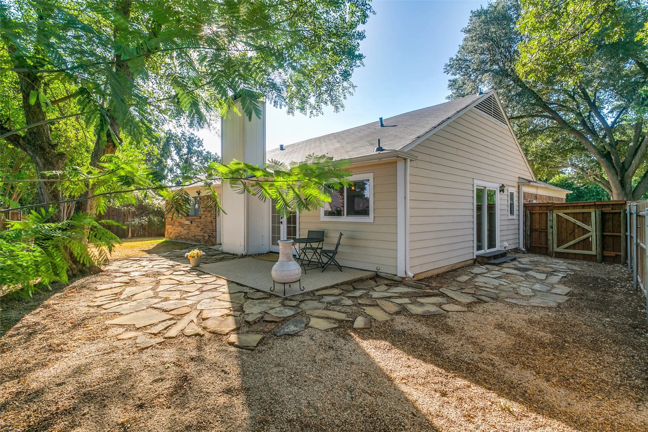 The living room double doors and kitchen slider door both open to the backyard. The main patio is enhanced with an extended stone patio and walkways.