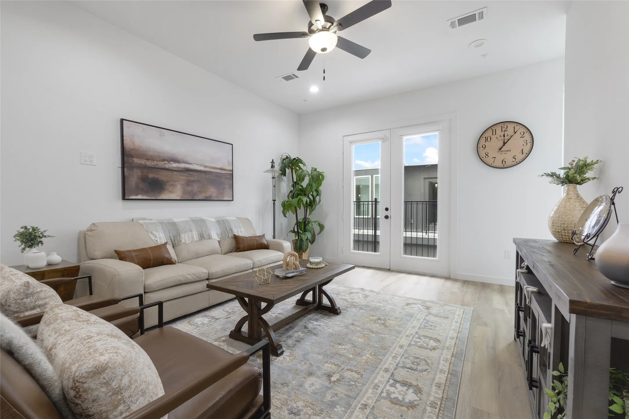 Recessed lighting, ceiling fan, wood-finish flooring, and double French doors opening to a balcony