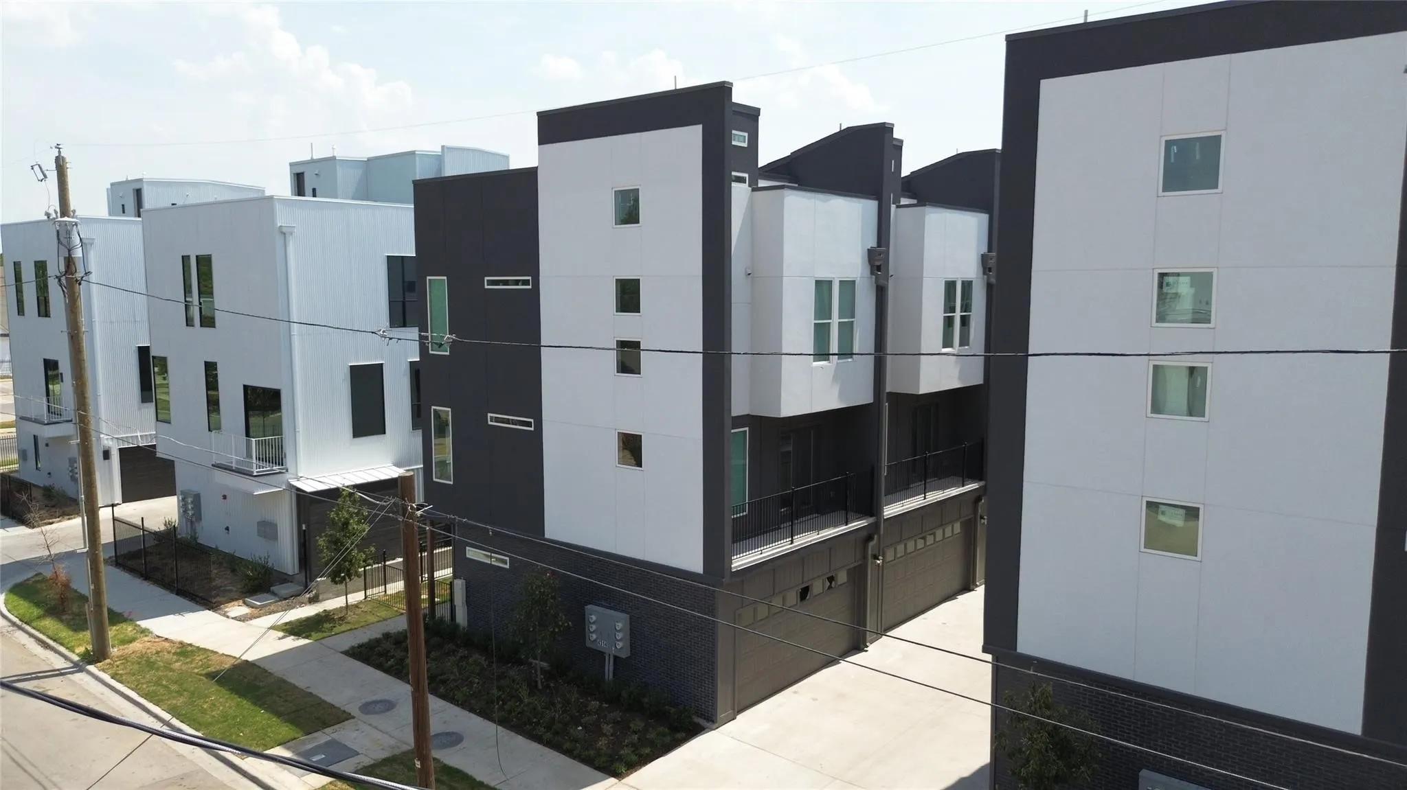 Modern architectural design featuring varied facade materials, multiple windows, and integrated garage doors