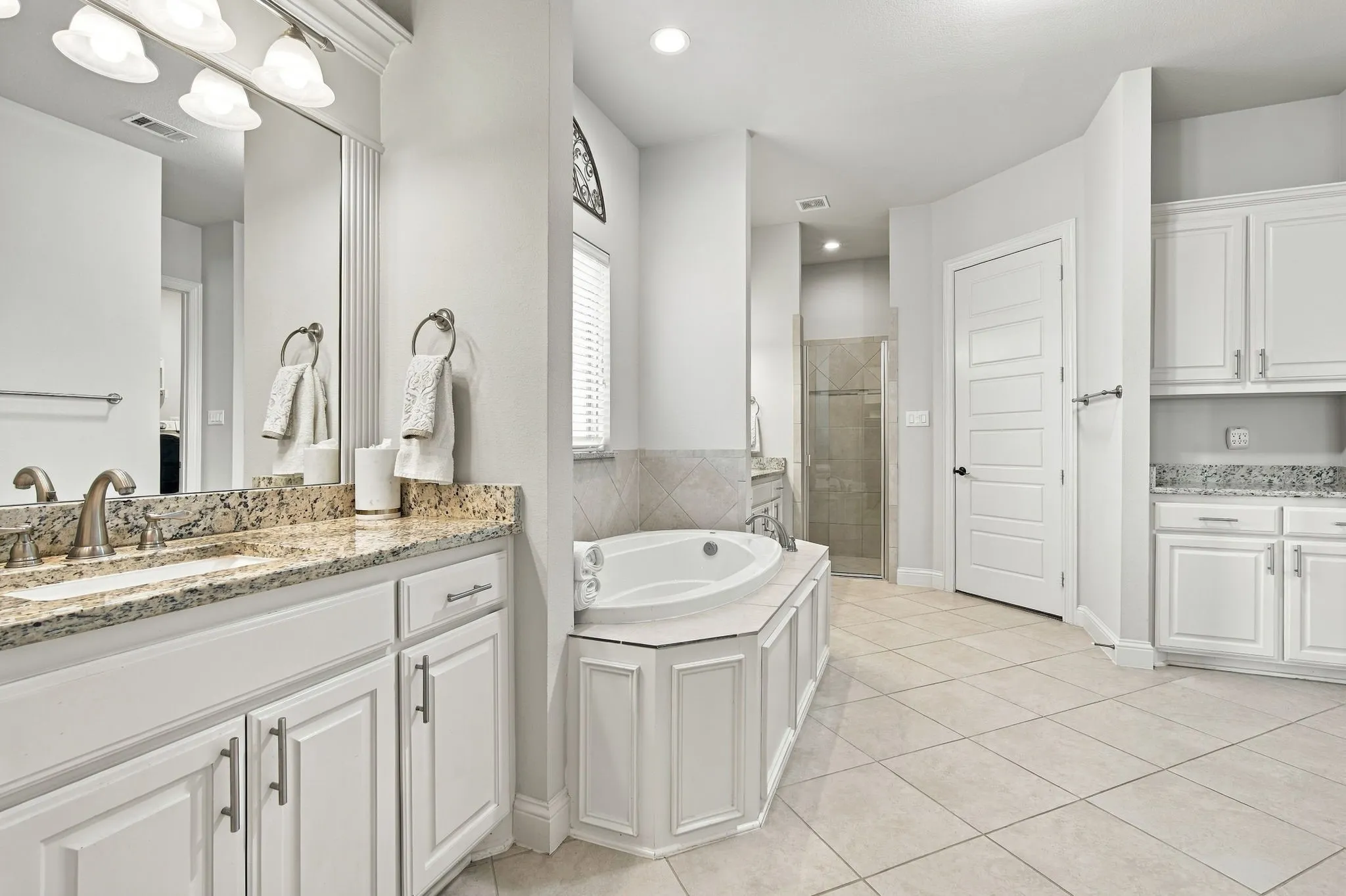 Separate his and hers vanities and closets as well as a walk-in shower and separate bathtub