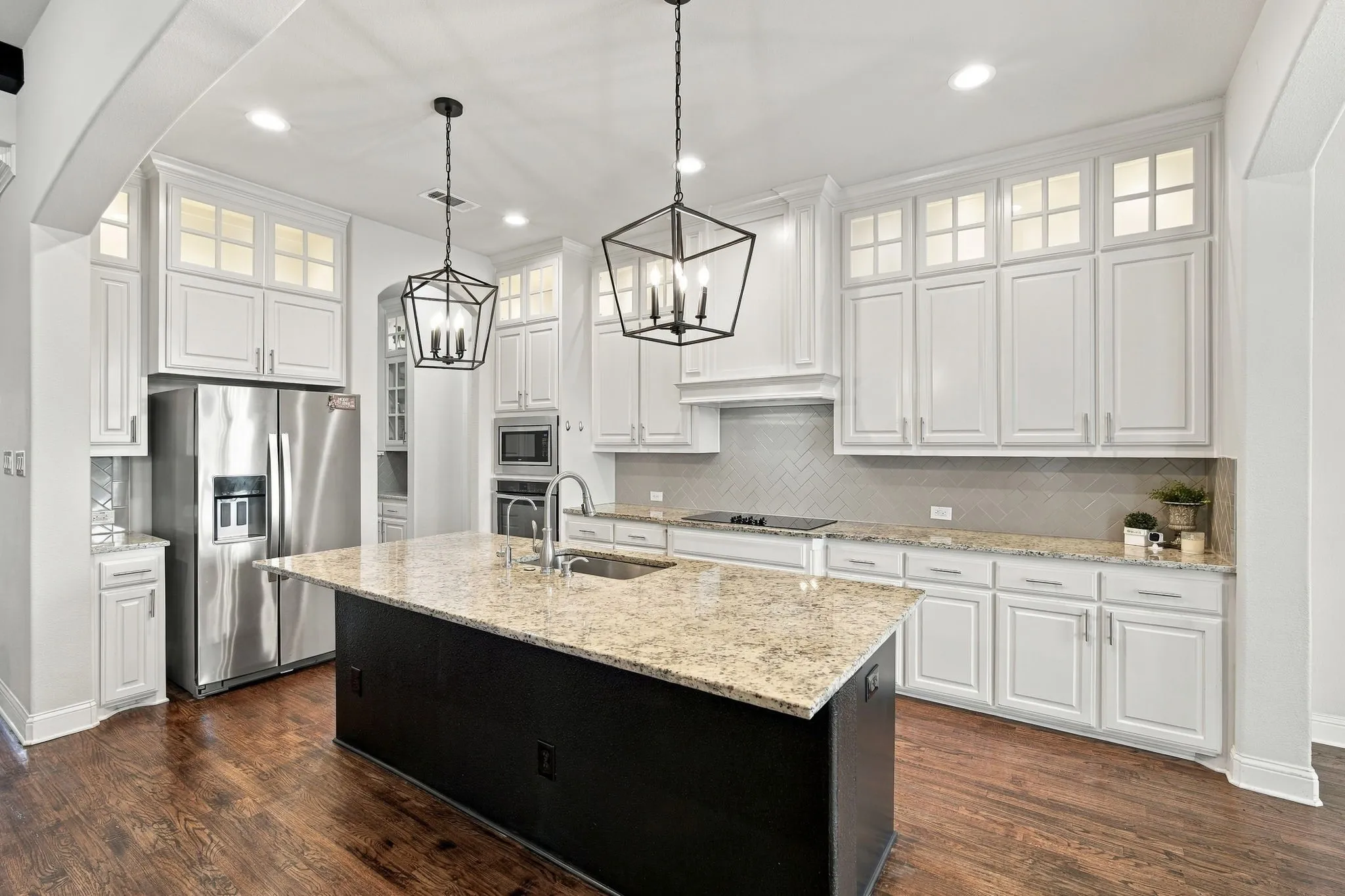 Open, sunny kitchen with hardwood flooring, granite countertops, and plenty of lighting for any occasion.
