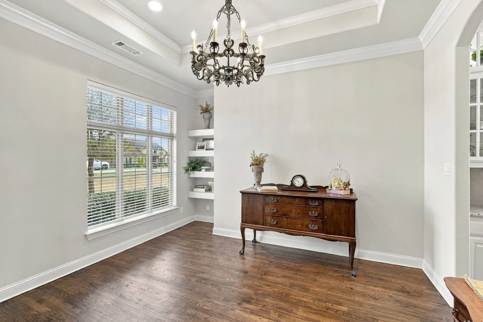 Beautiul hardwood floors, tray ceiling, and shelving make this a perfect space for an office