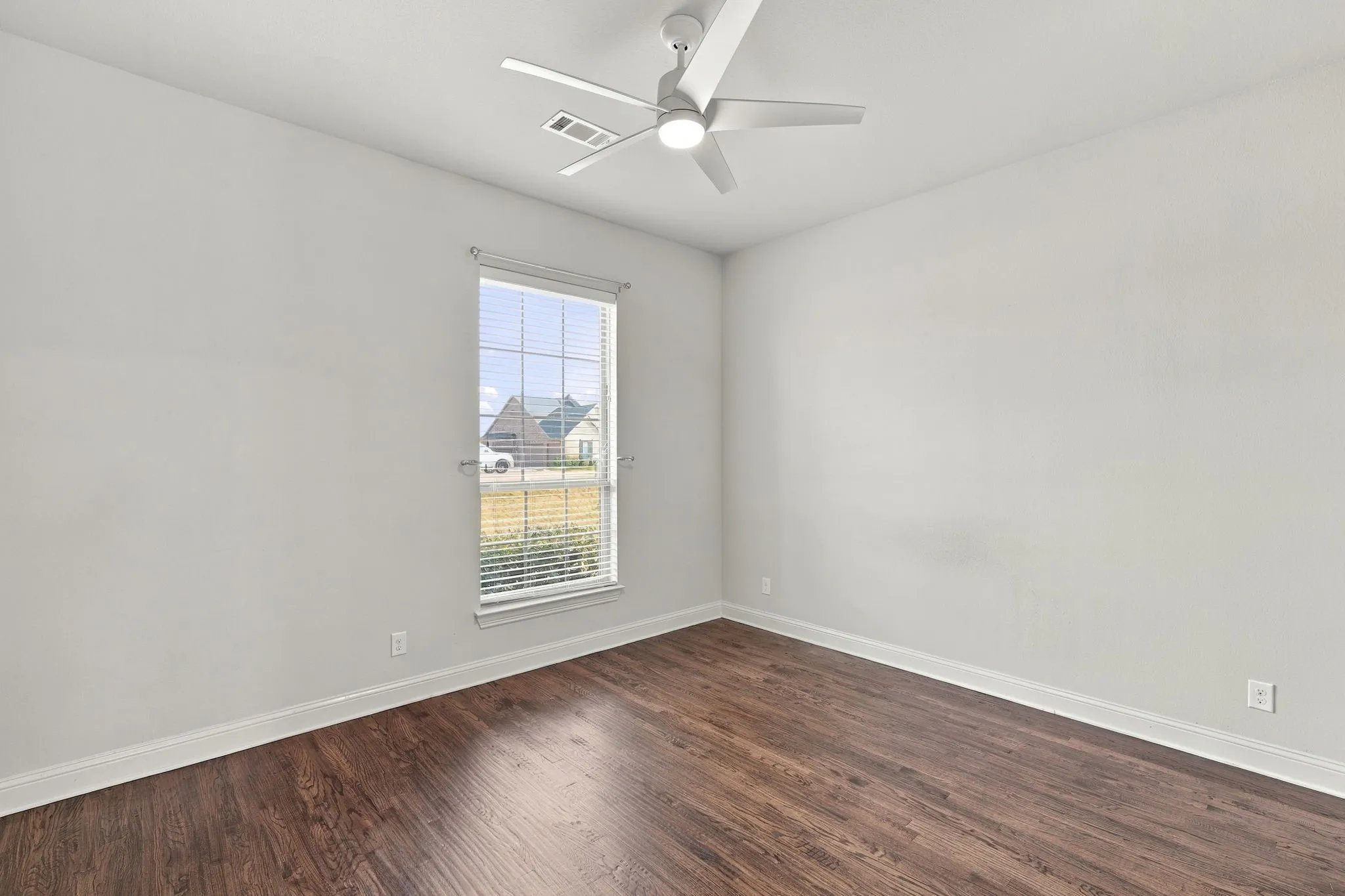 Spacious guest bedroom offers Hardwood floors and looks over the front lawn.