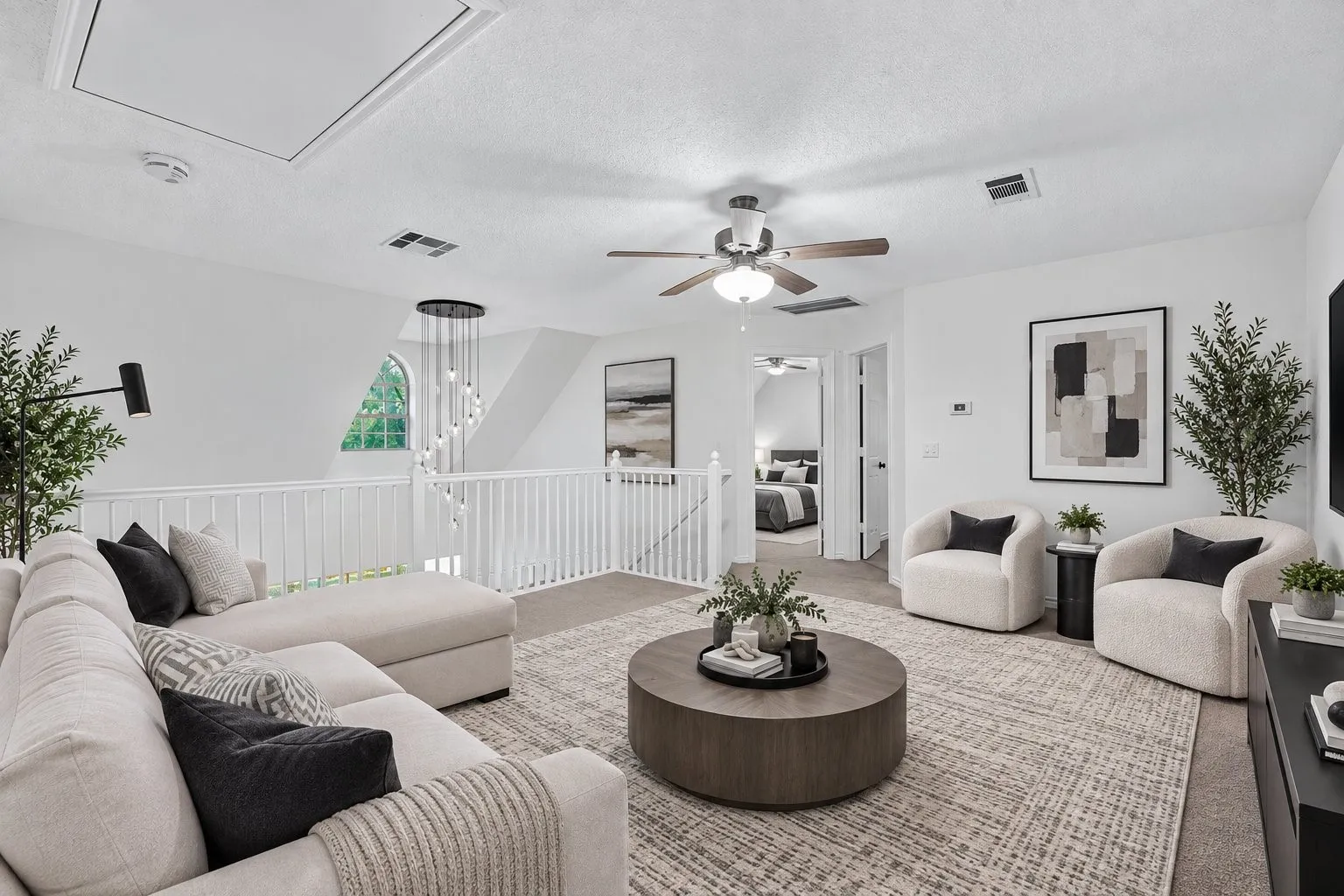 Open-concept loft space with carpet flooring, a ceiling fan, and a contemporary railing