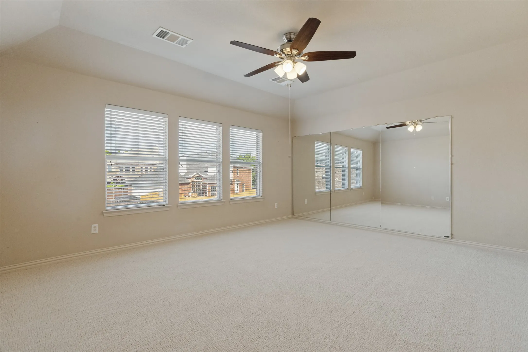 Oversized upstairs game room offers plenty of space for entertaining and relaxing, featuring brand-new carpet, a ceiling fan, and abundant natural light.