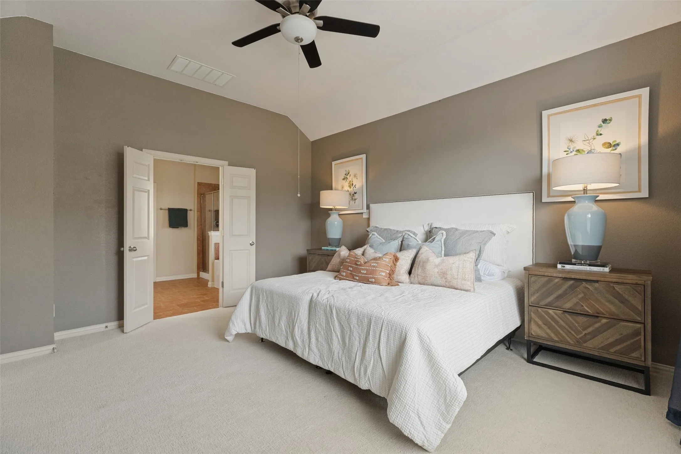 Generously sized primary suite offers plenty of room to unwind, with a vaulted ceiling and convenient access to the private ensuite bath.