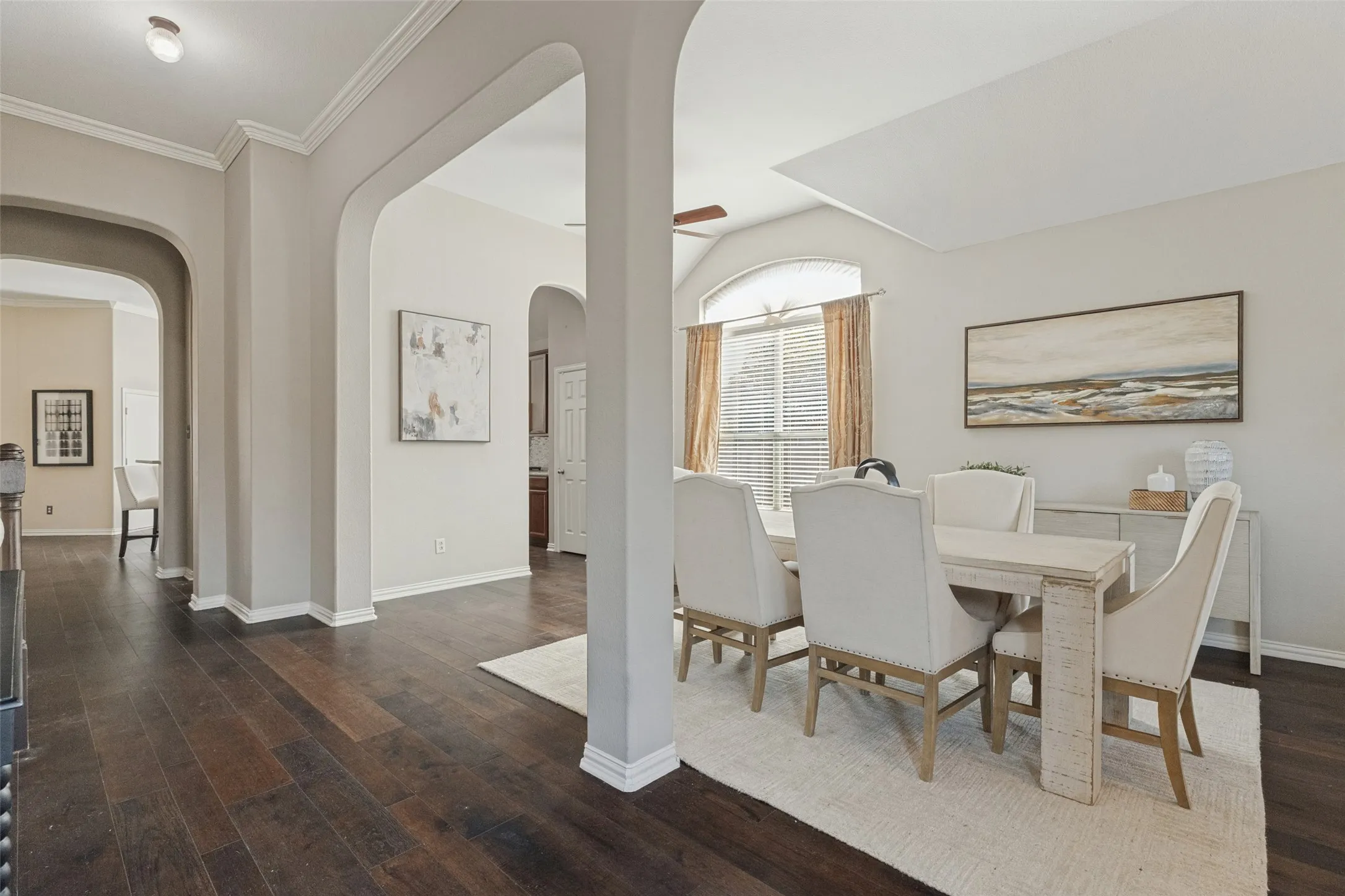 Another view of the spacious dining area highlights the soaring ceilings, beautiful architectural arches, rich hardwood floors, and large windows that bring in abundant natural light.