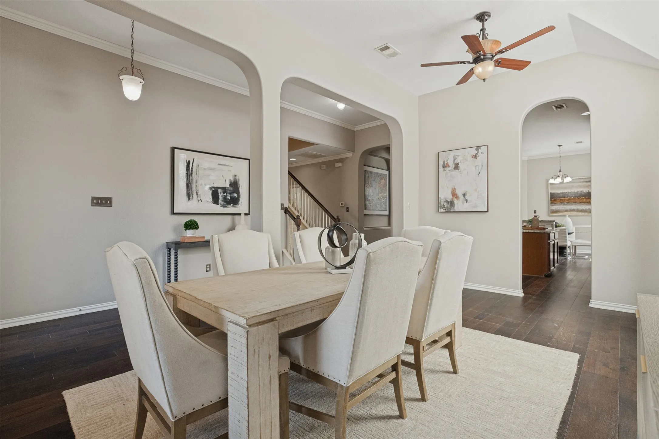 The formal dining room flows seamlessly into the heart of the home, with soaring ceilings, graceful archways, rich hardwood floors, and an open layout ideal for entertaining.