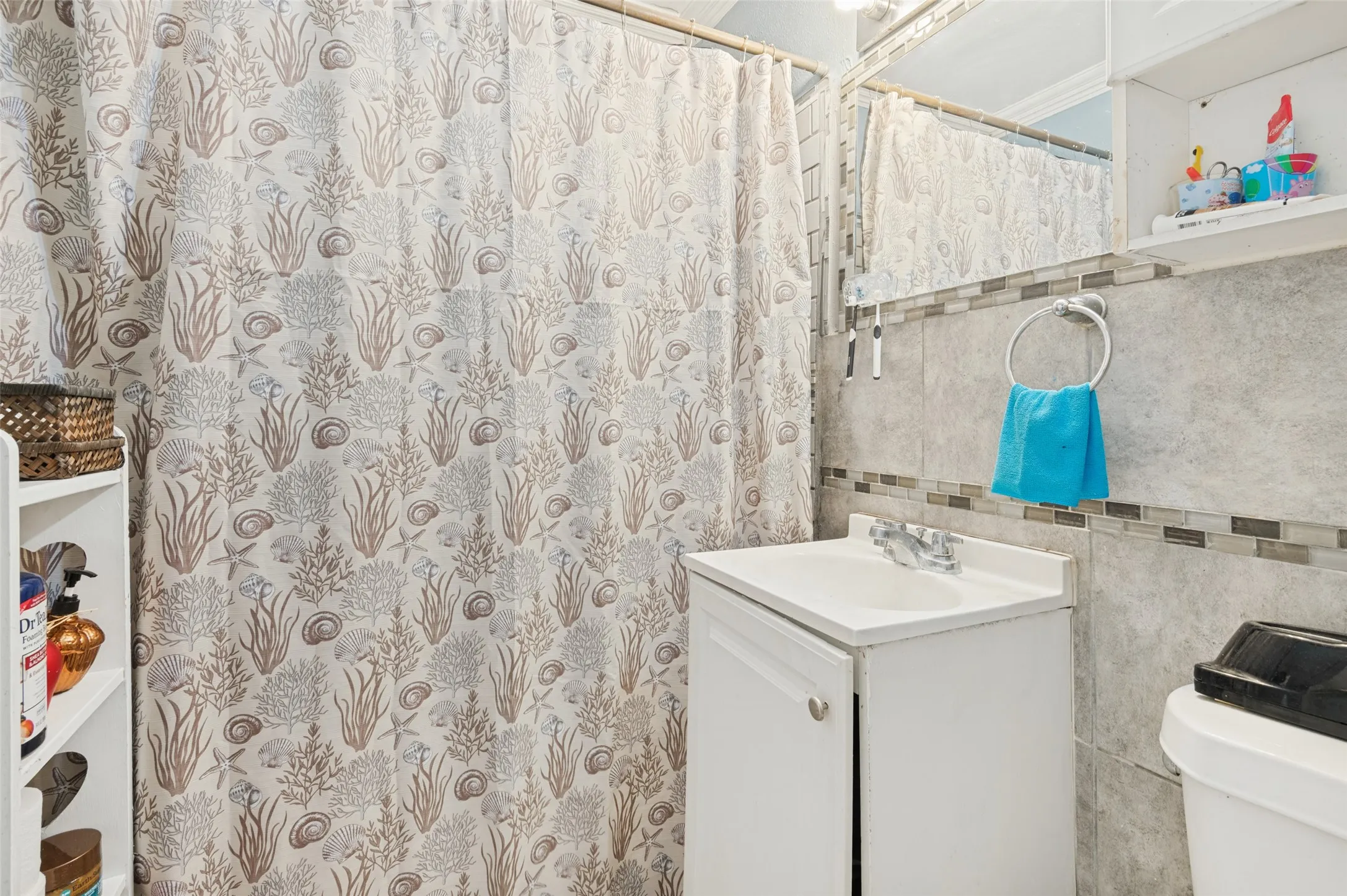 Full bathroom featuring a single vanity with integrated sink, chrome faucet, tiled walls, and a recessed medicine cabinet