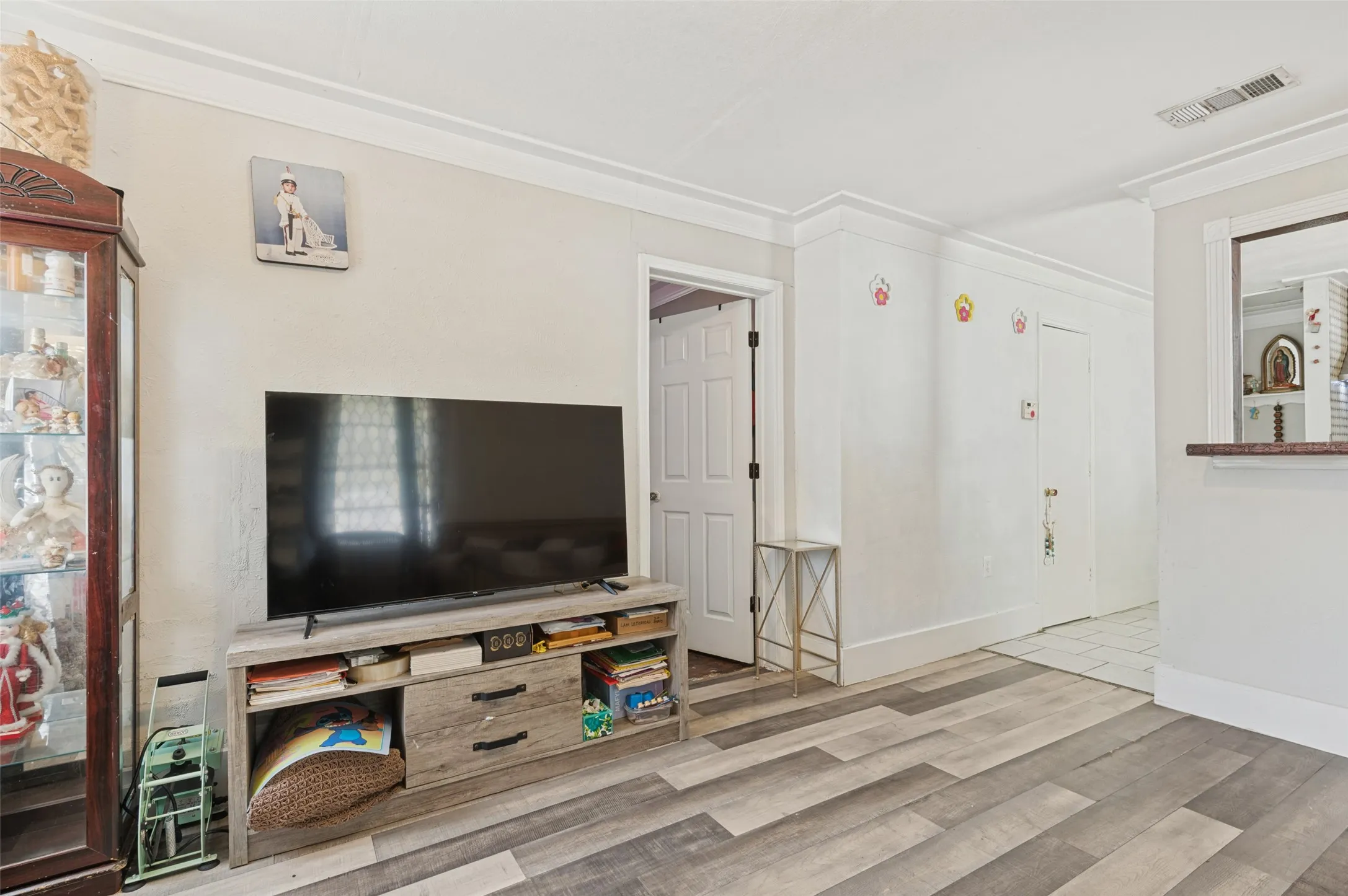 Wood-finish flooring with crown molding and white trim