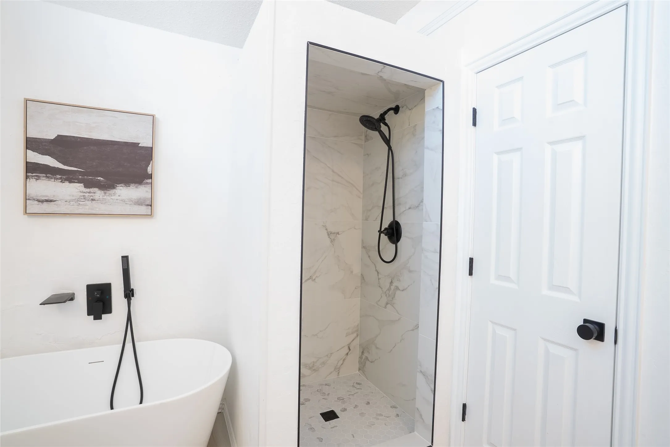 Freestanding soaking tub with matte black fixtures, walk-in shower with marble-look tile, and modern black showerhead