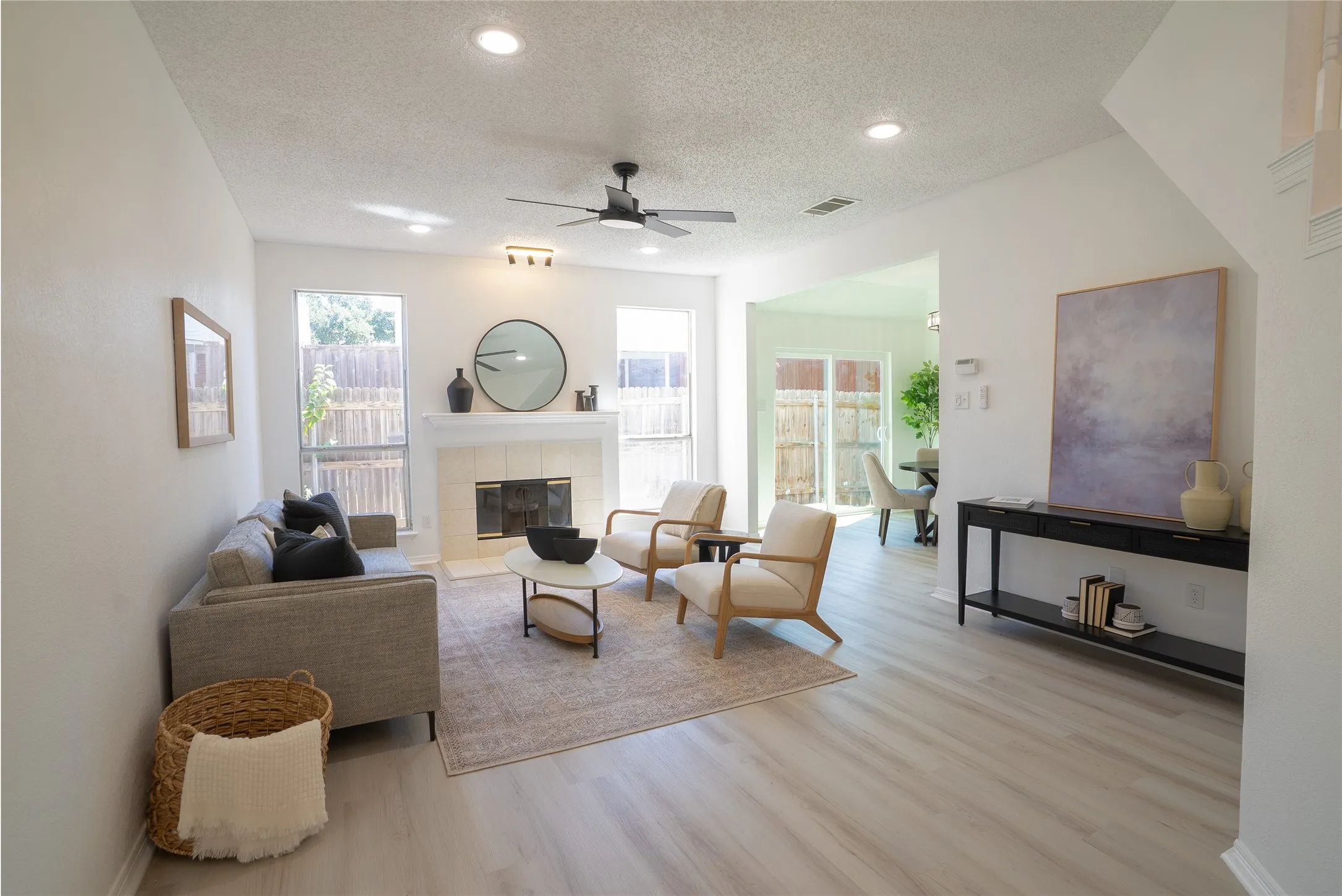Bright living area featuring wood-finish flooring, recessed lighting, a ceiling fan, and a tiled fireplace