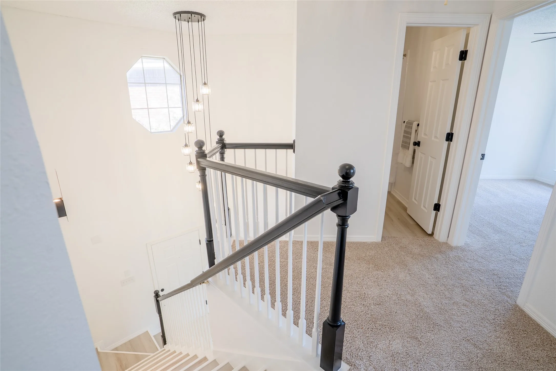 Staircase featuring dark wood handrail, white balusters, and light wood-finish treads