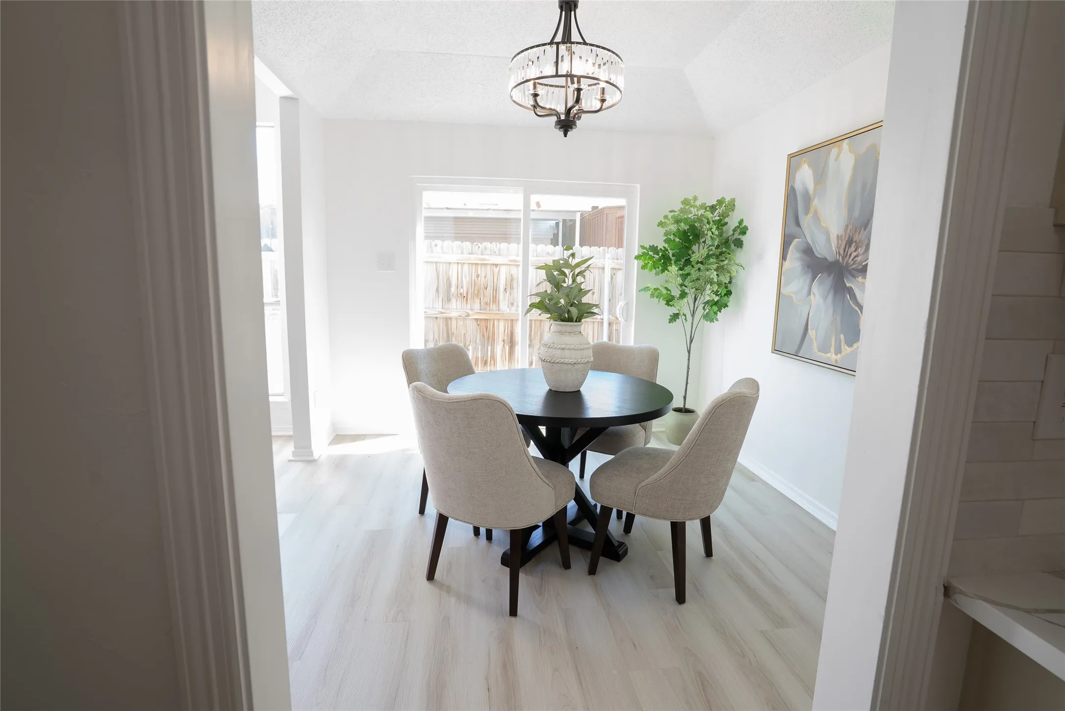 Recessed lighting, vaulted ceiling, wood-finish flooring, sliding glass door, and a decorative chandelier