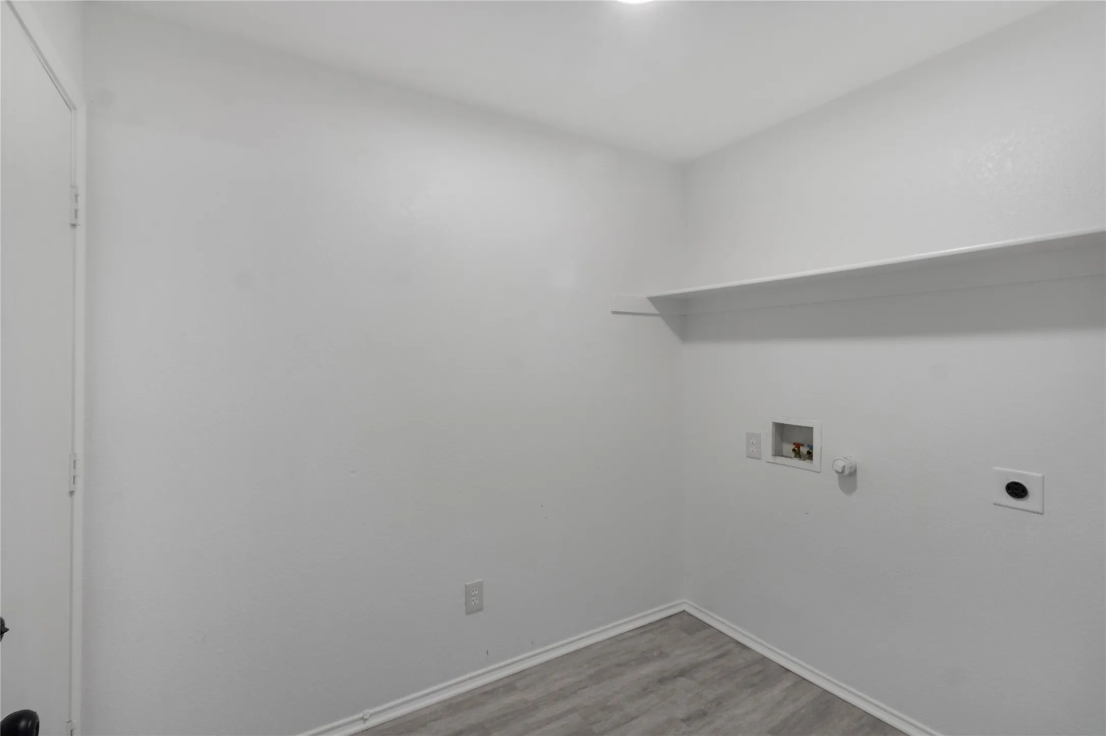 Built-in shelving, white walls, and wood-finish flooring