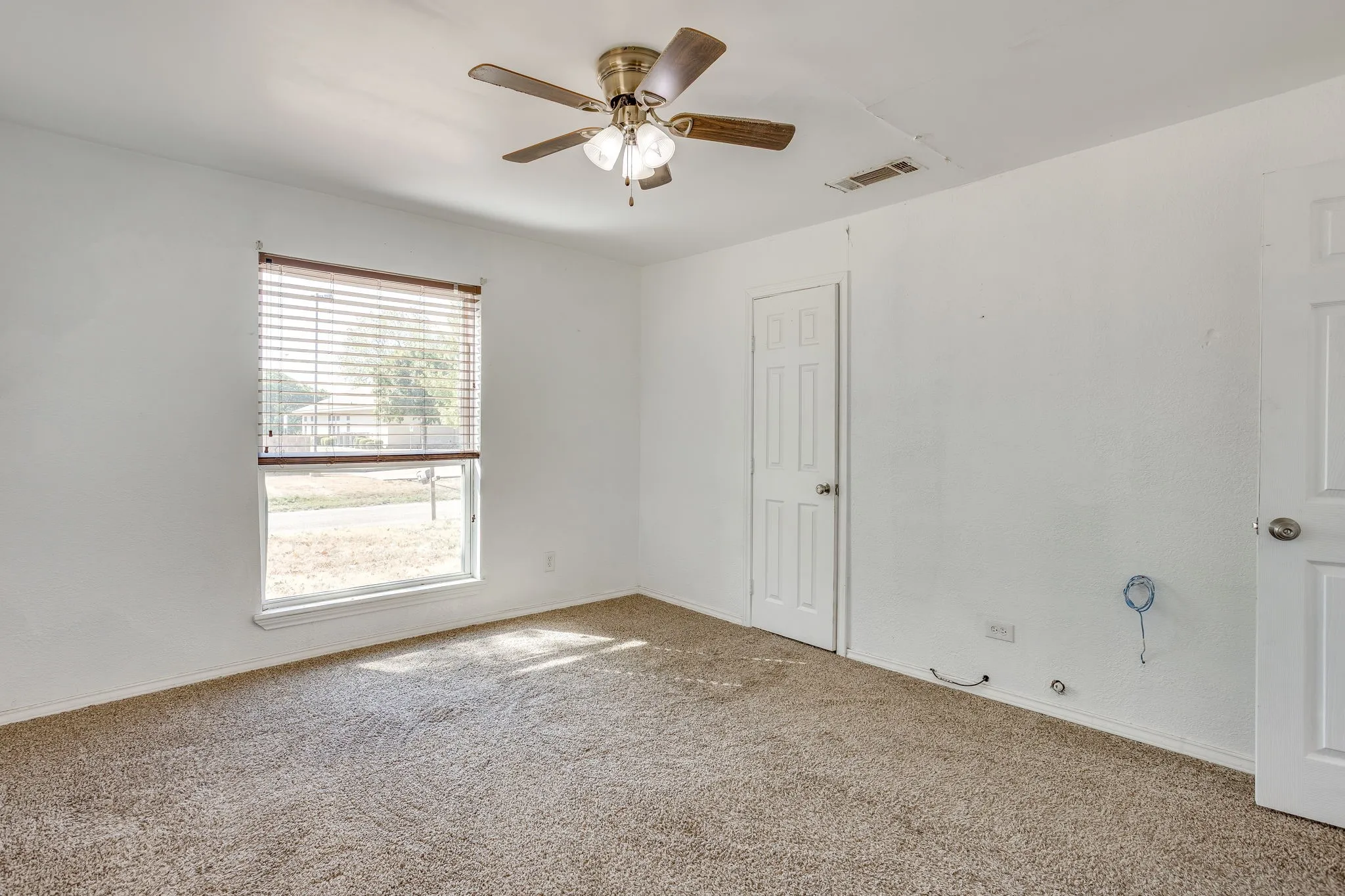 Secondary bedroom with reach in closet, carpet new in 2024, ceiling fan, and light and bright.