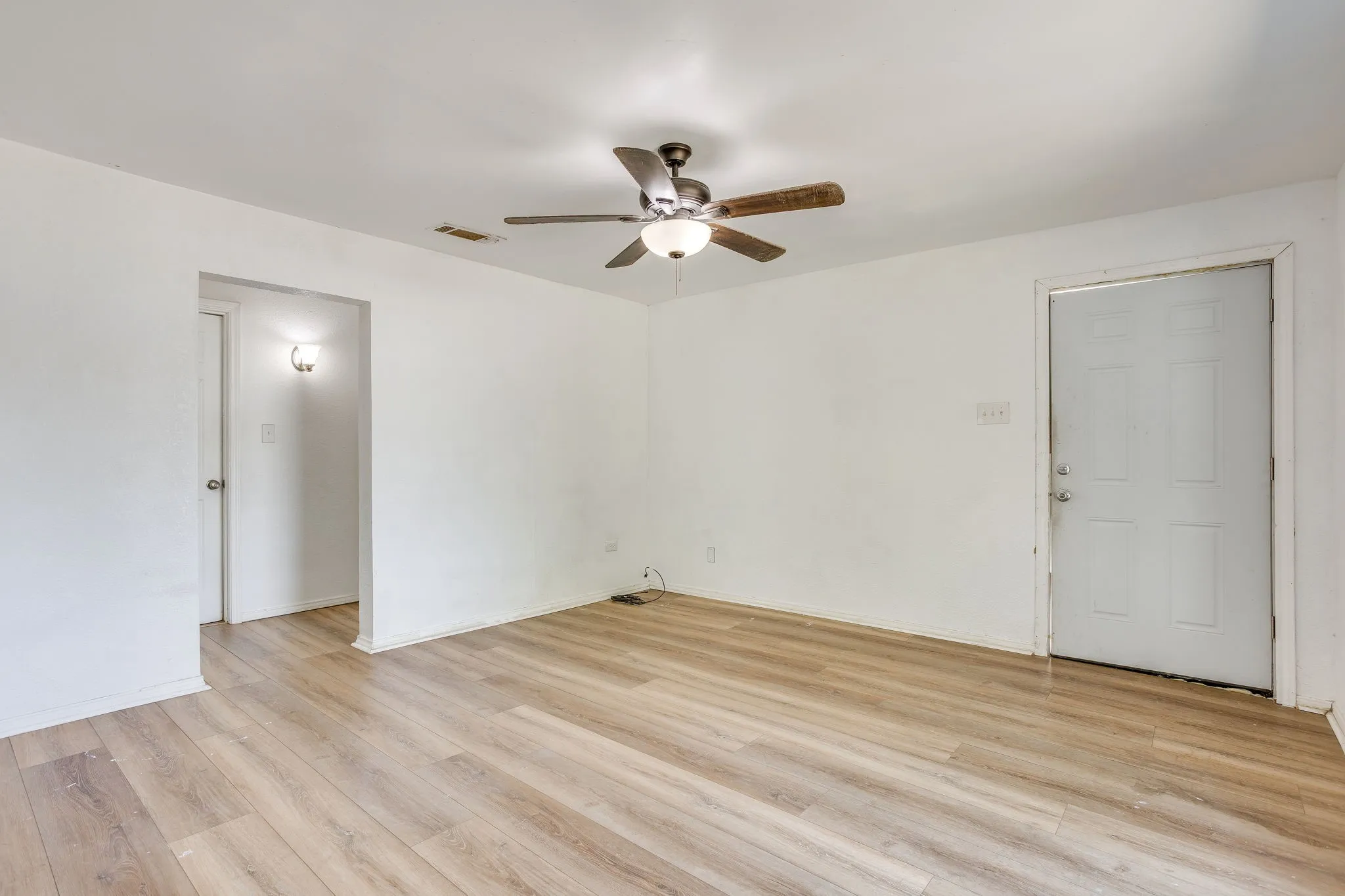 Living room to hallway with laminate flooring extending through main spaces.
