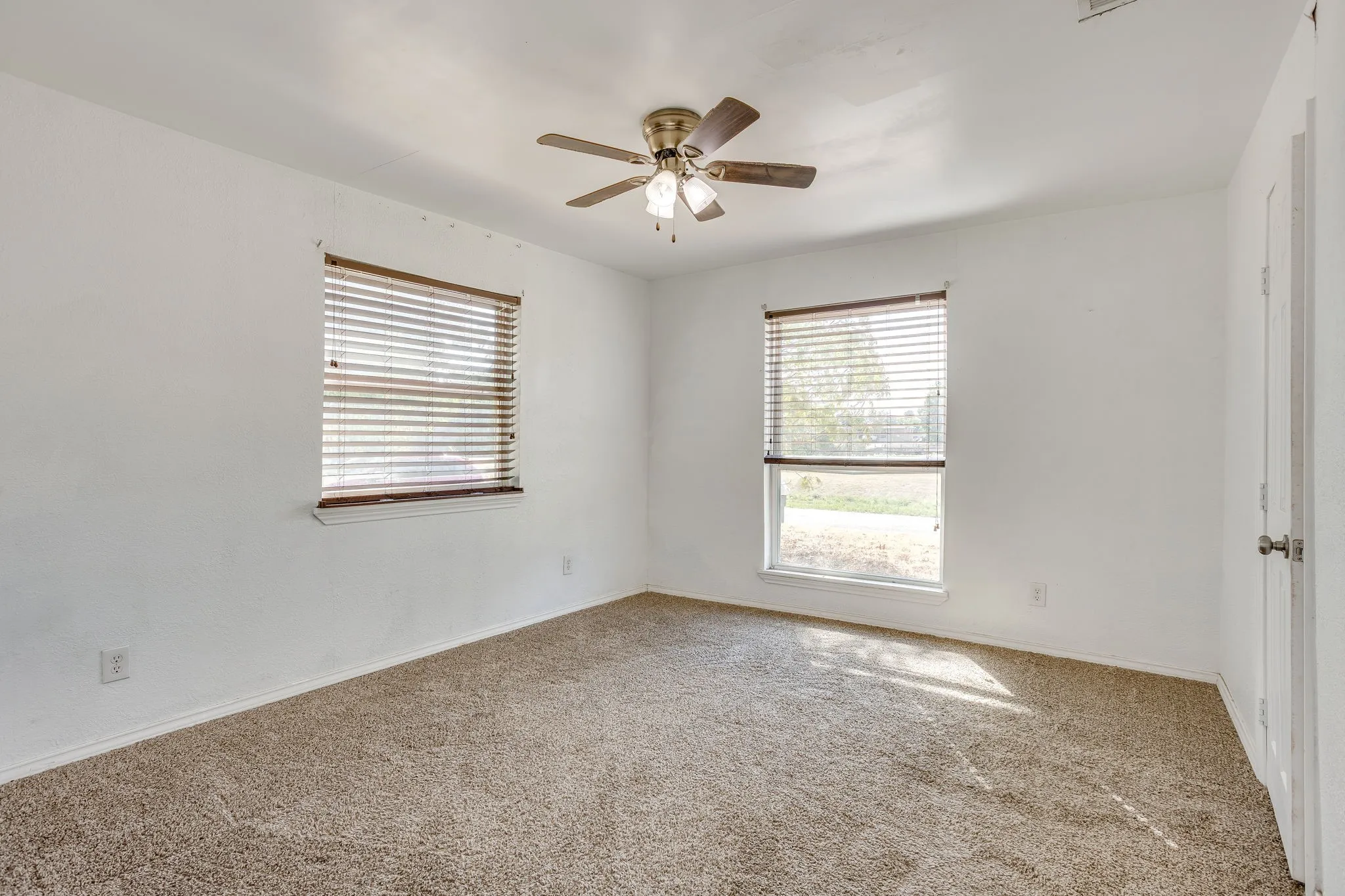 Bedroom with fresh carpet 2024, great natural light and ceiling fan.