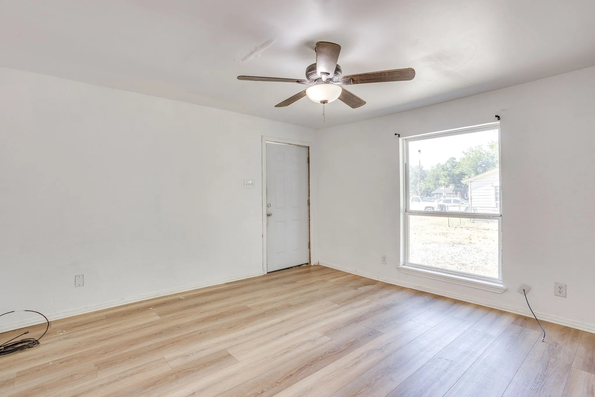 Large living room with laminate flooring, ceiling fan, and great natural light.