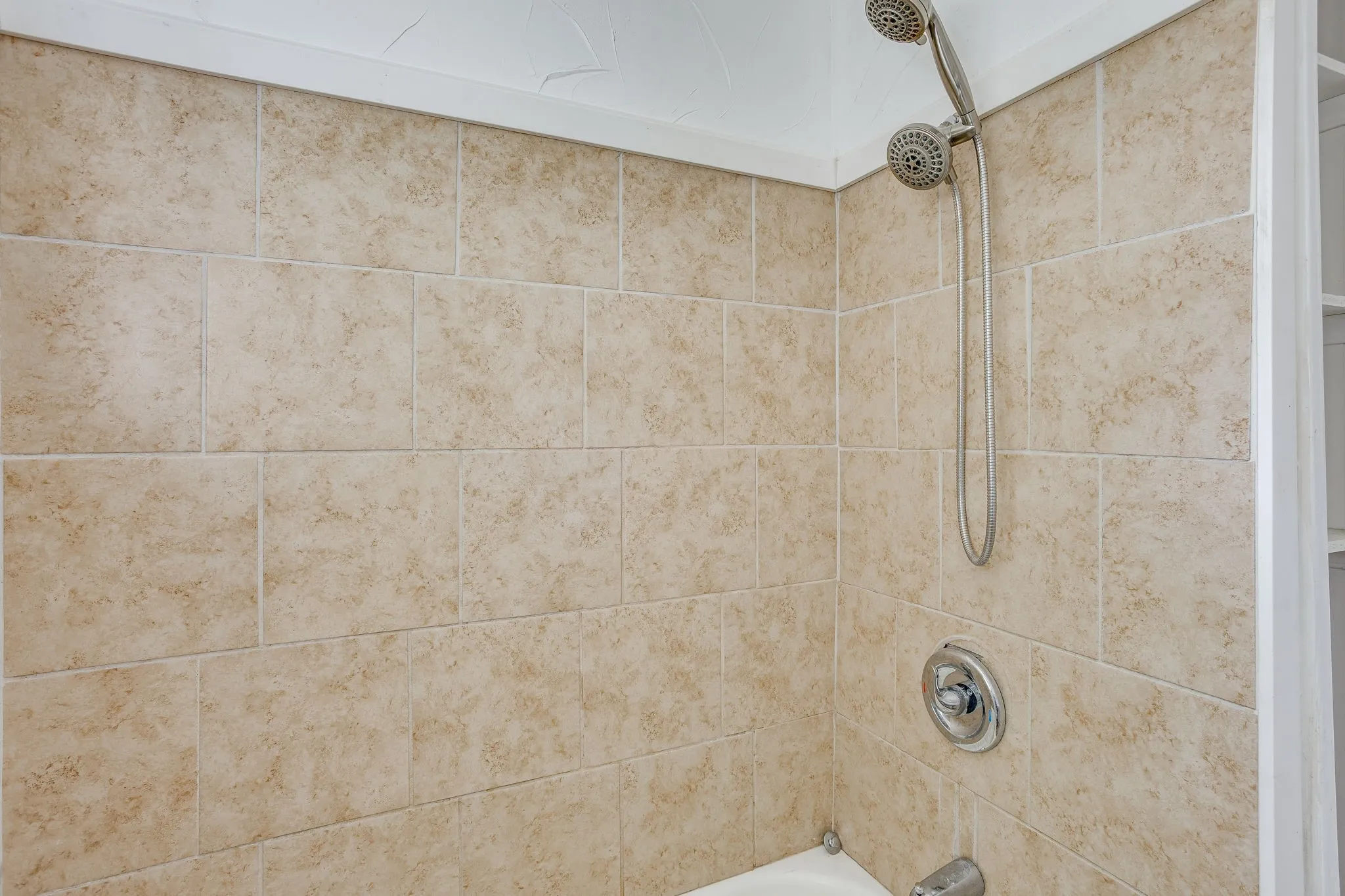 Tiled shower and tub with removable shower head.