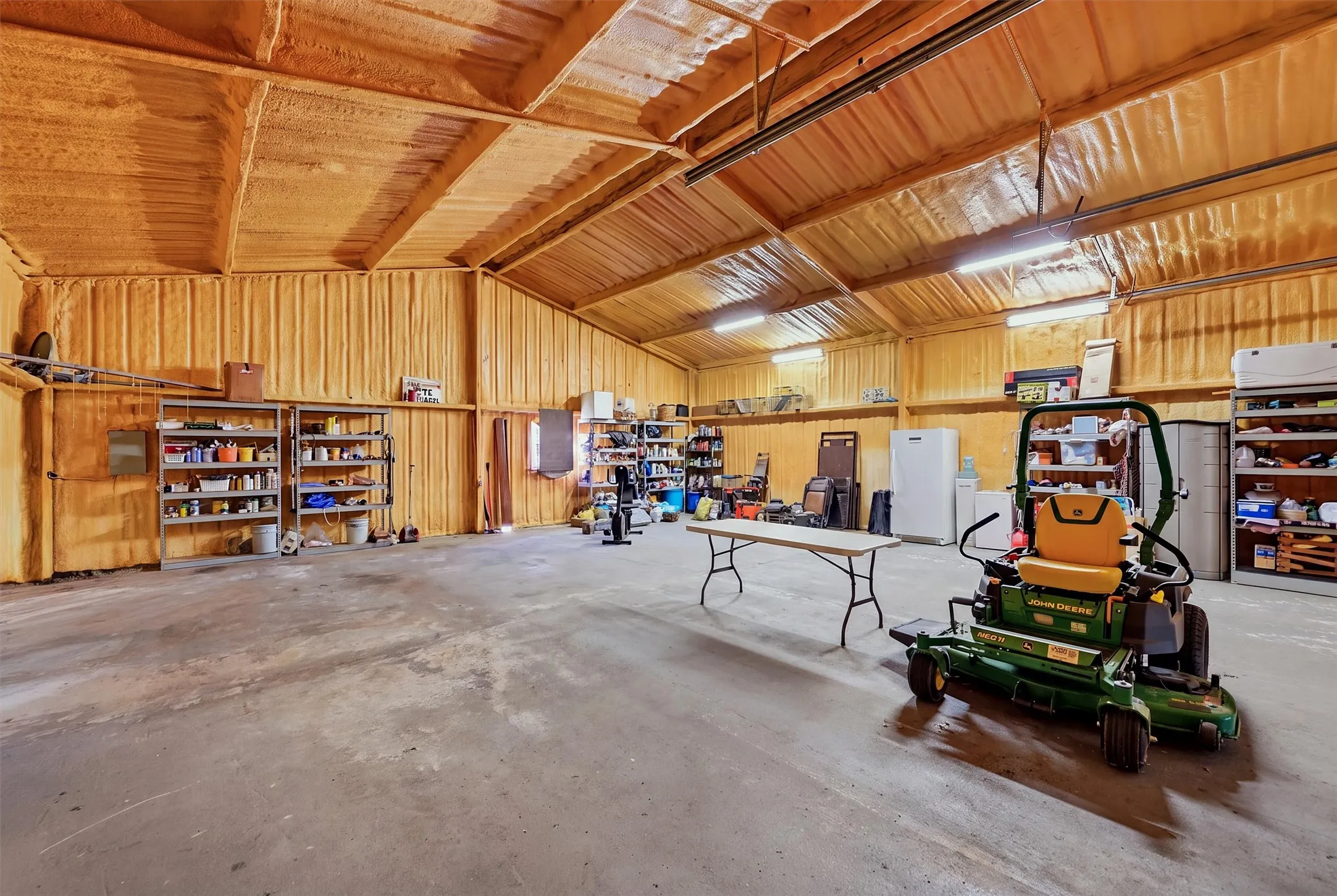 Spacious utility building with vaulted ceilings, exposed beams, and concrete flooring