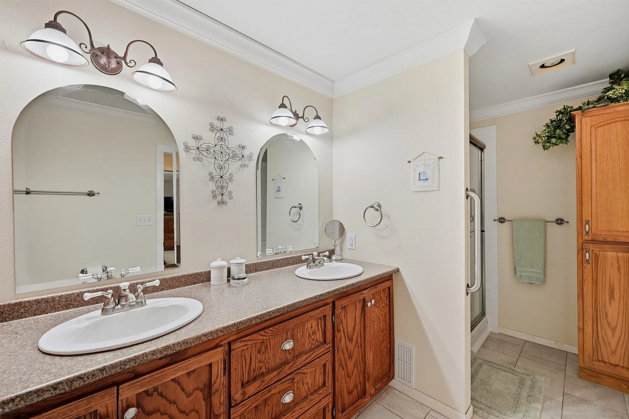 Dual vanity with undermount sinks, wood cabinetry, and a textured countertop