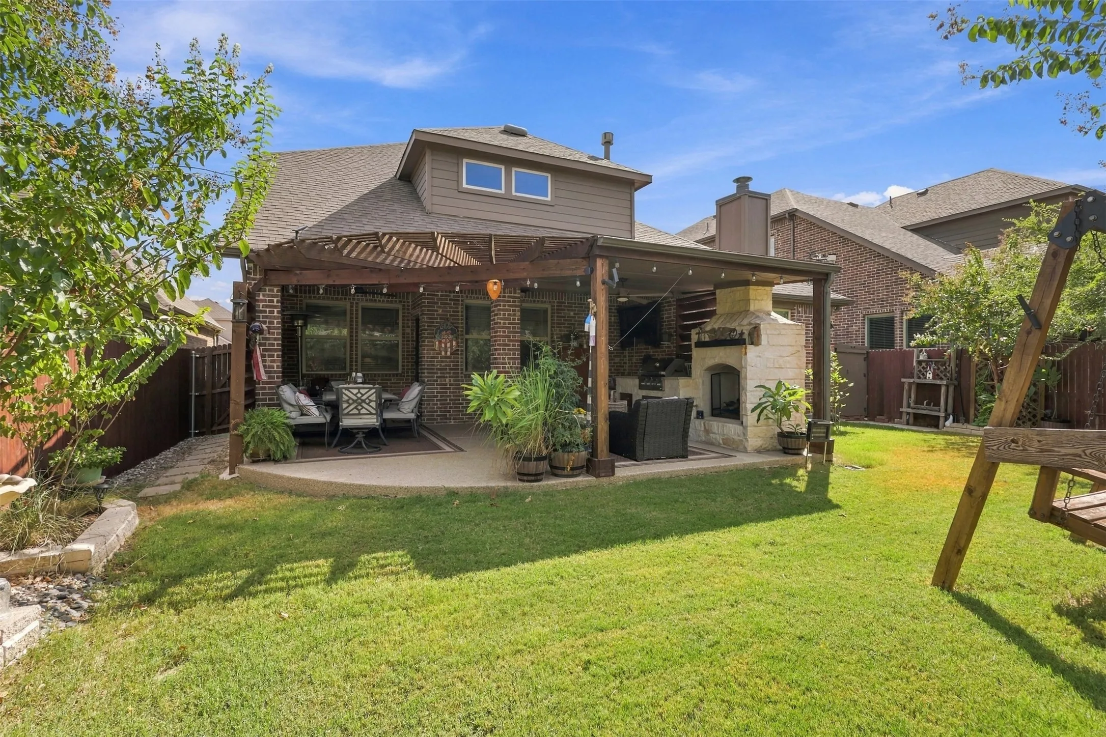 This patio is a dream! Extended pergola, built in fire place and grill great for entertaining.