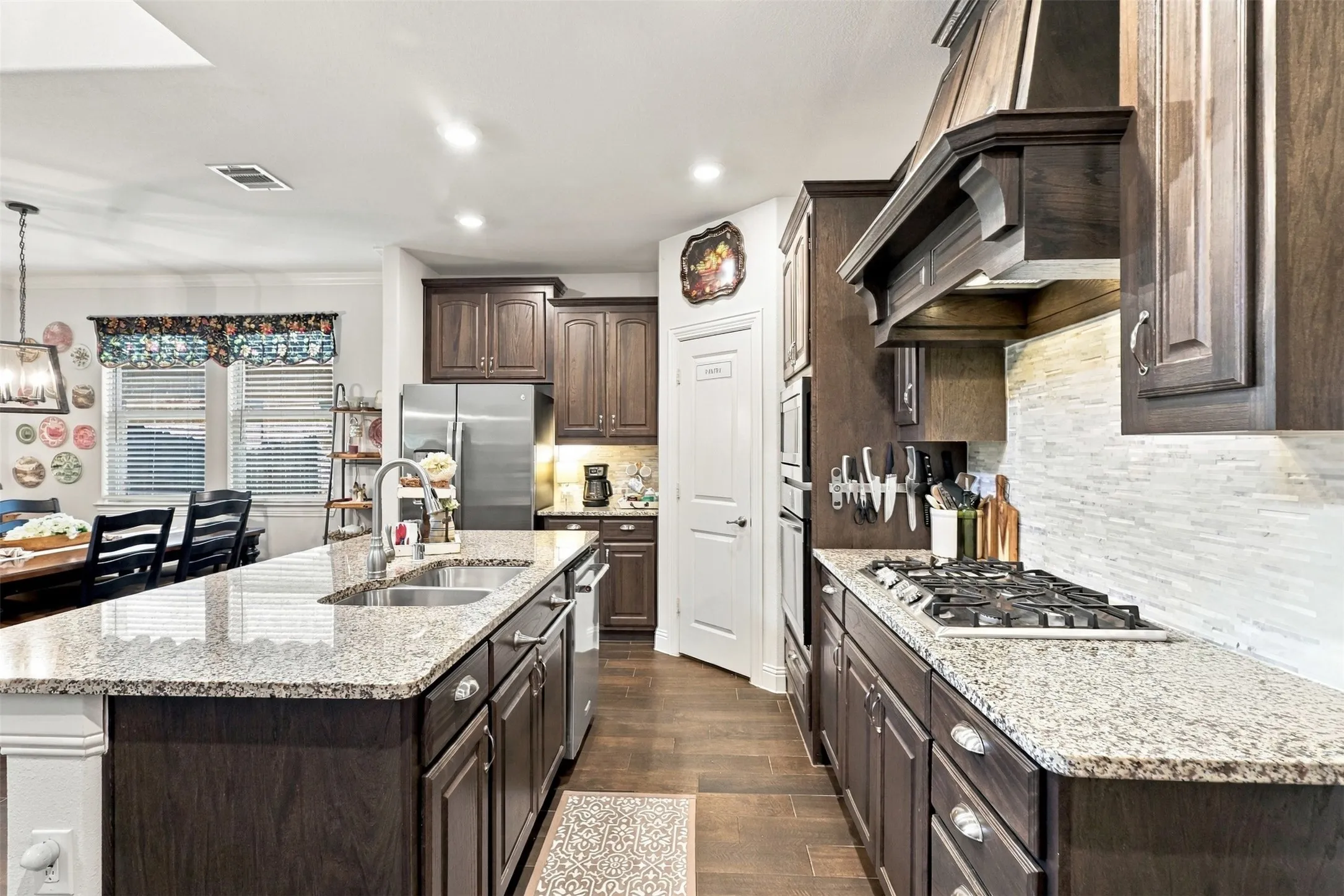 Gas stove, granite countertops and a walk in pantry open to the living and dining area