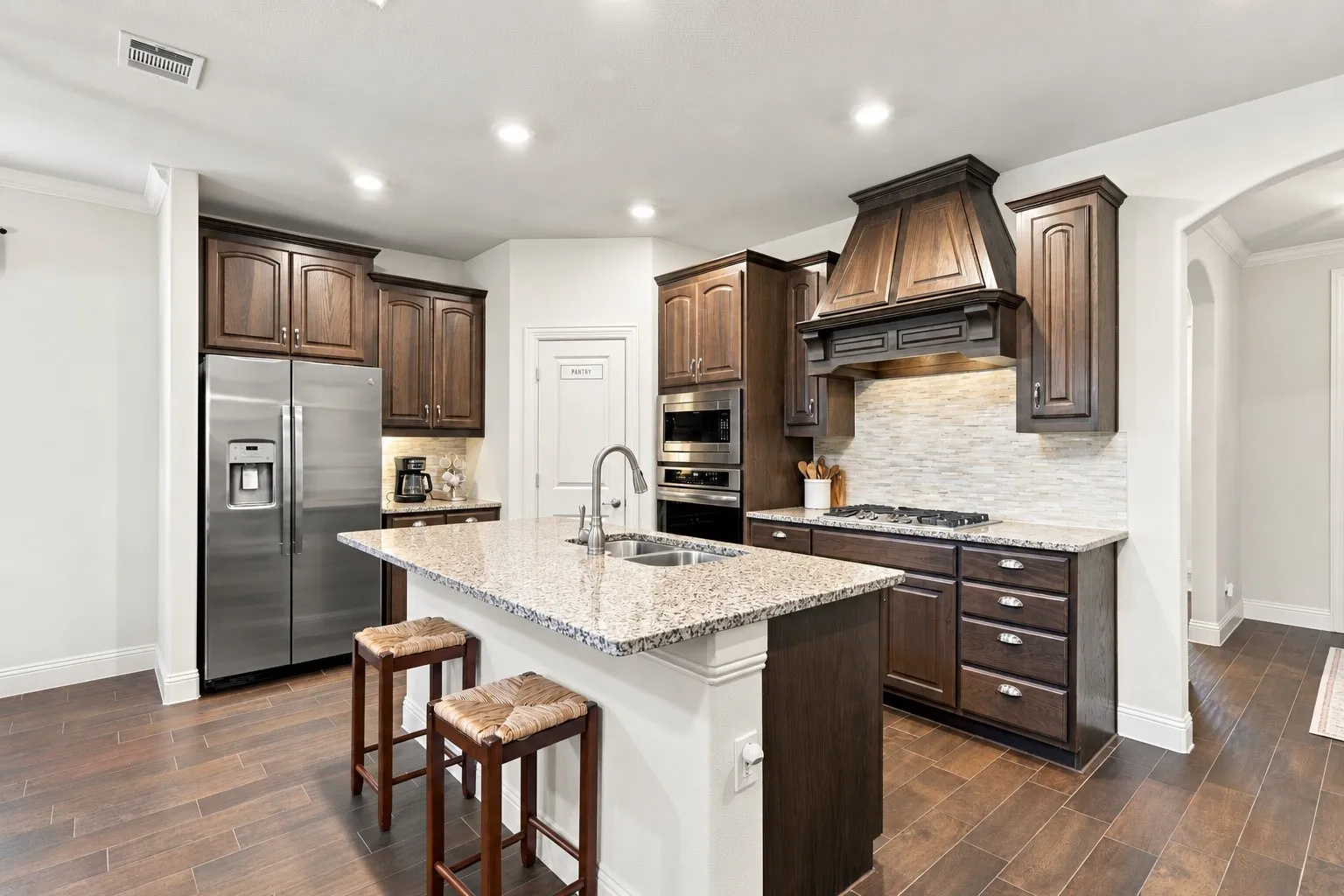 Gas stove, granite countertops and a walk in pantry open to the living and dining area