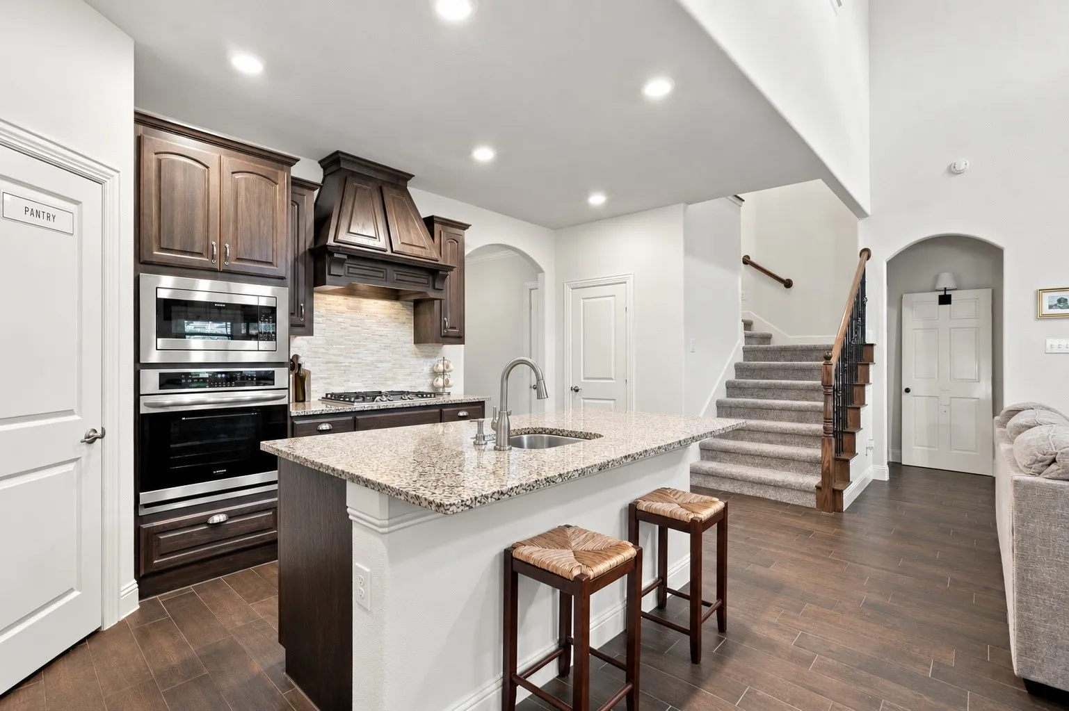 Gas stove, granite countertops and a walk in pantry open to the living and dining area