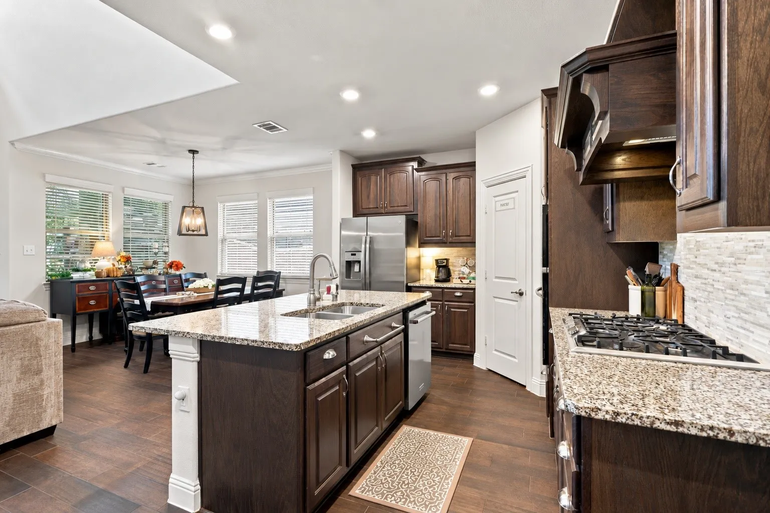 Gas stove, granite countertops and a walk in pantry open to the living and dining area