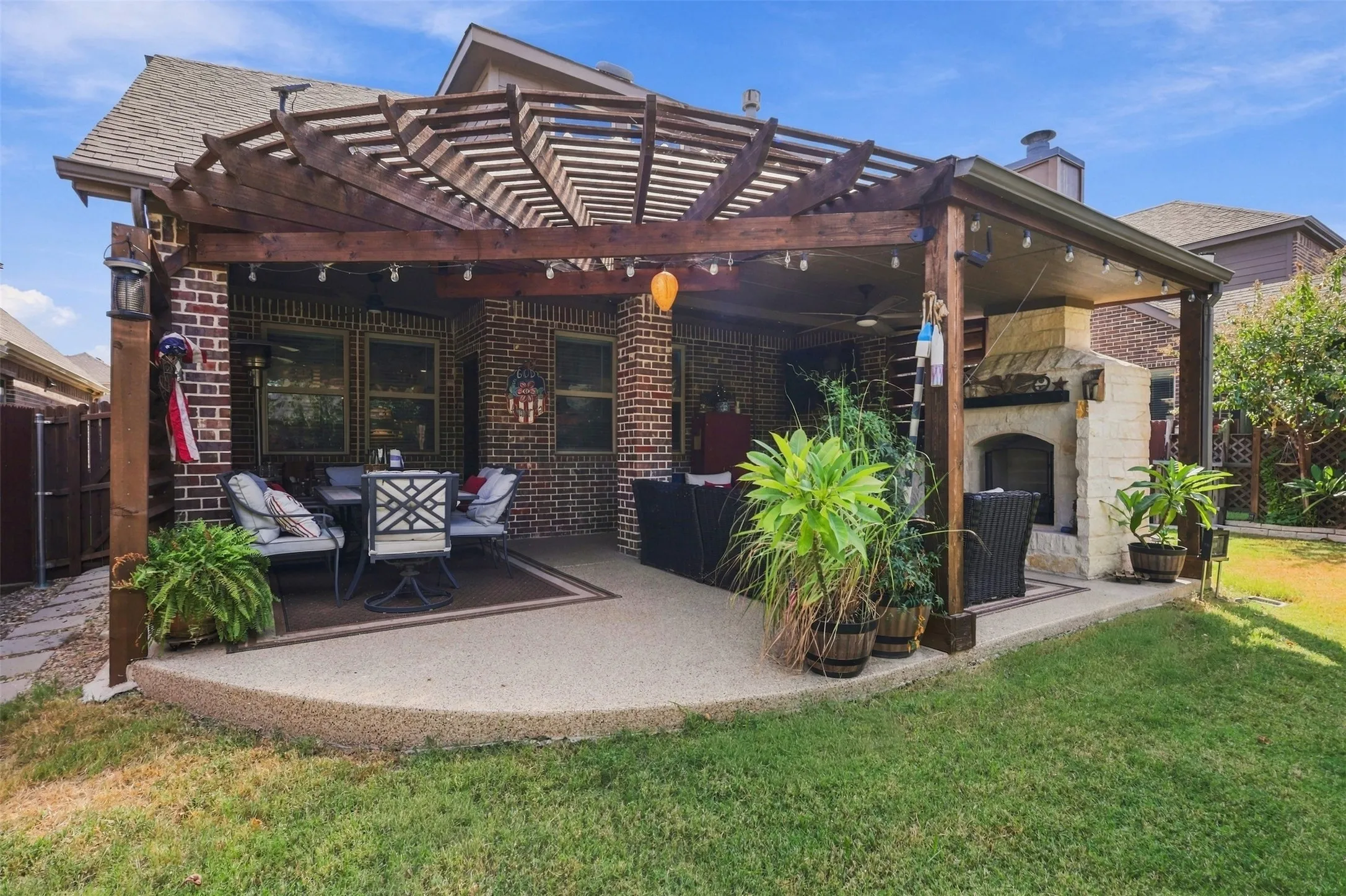 This patio is a dream! Extended pergola, built in fire place and grill great for entertaining.