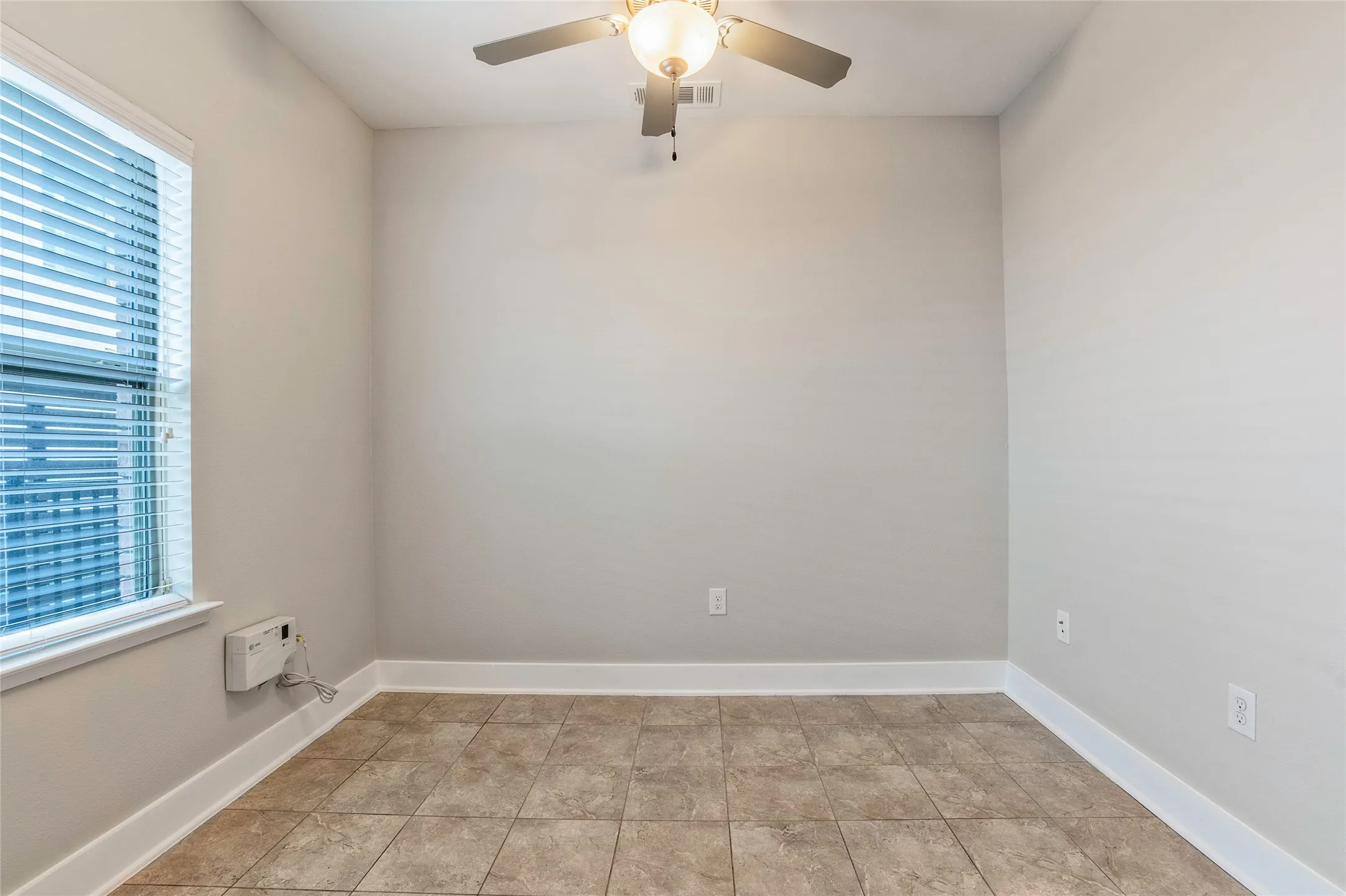 Recessed window with blinds, overhead ceiling fan with lighting, and tiled flooring