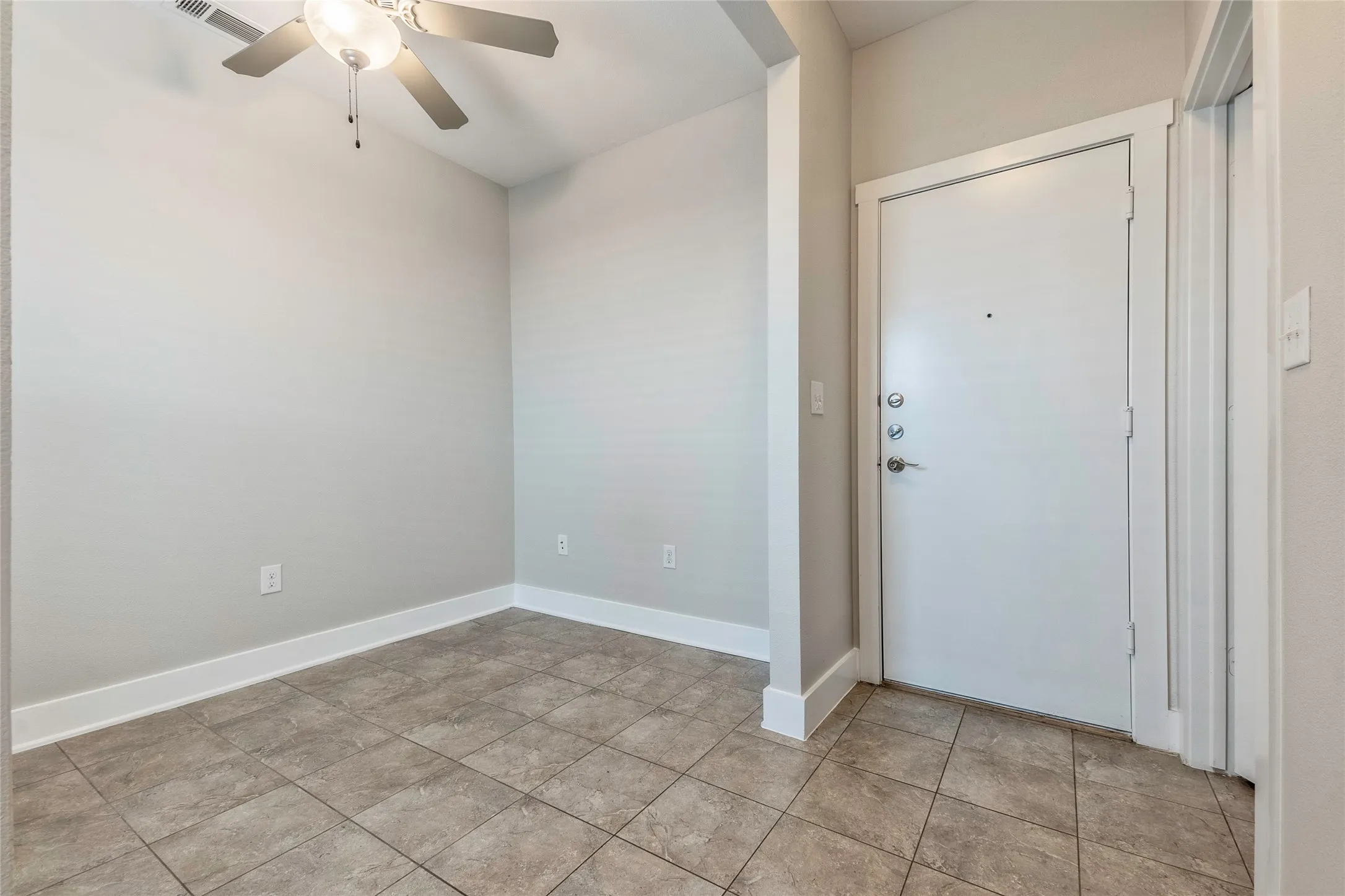 Ceramic tile flooring, light neutral wall paint, and a ceiling fan with integrated lighting