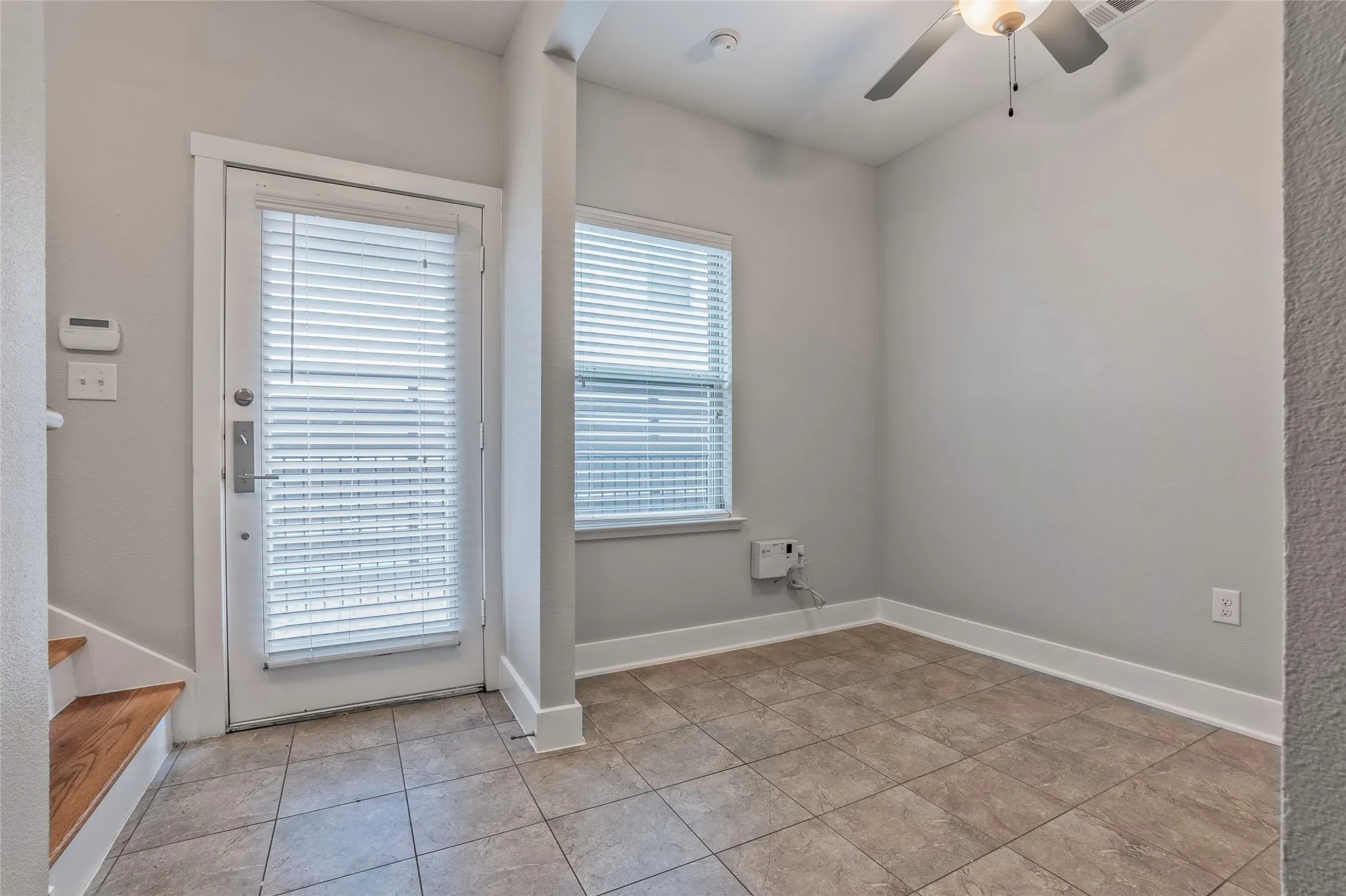 Tiled flooring, white trim, and a ceiling fan