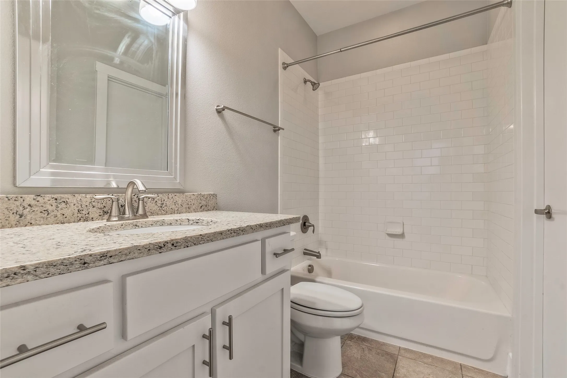 Vanity with stone-finish countertop, undermount sink, and brushed nickel faucet